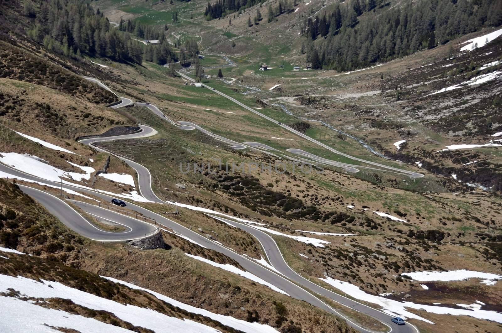 Mountain pass road through snow covered rocks on Spluegen Pass in Switzerland, Europe