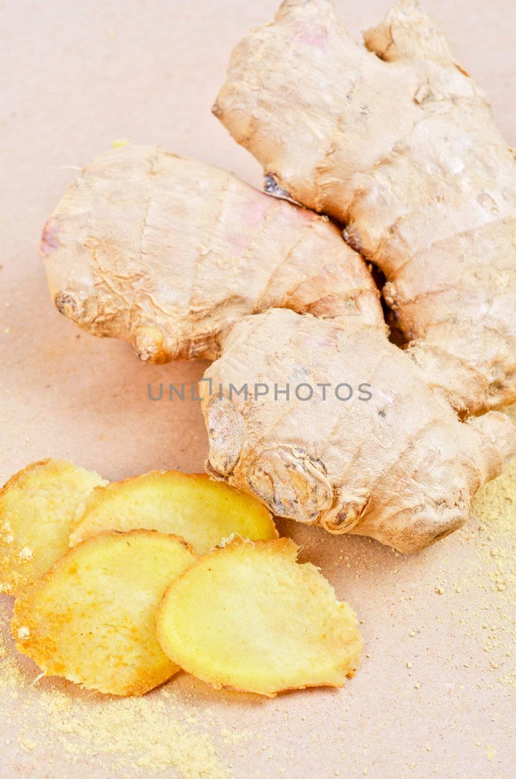 Fresh, dried and powdered ginger at brown background