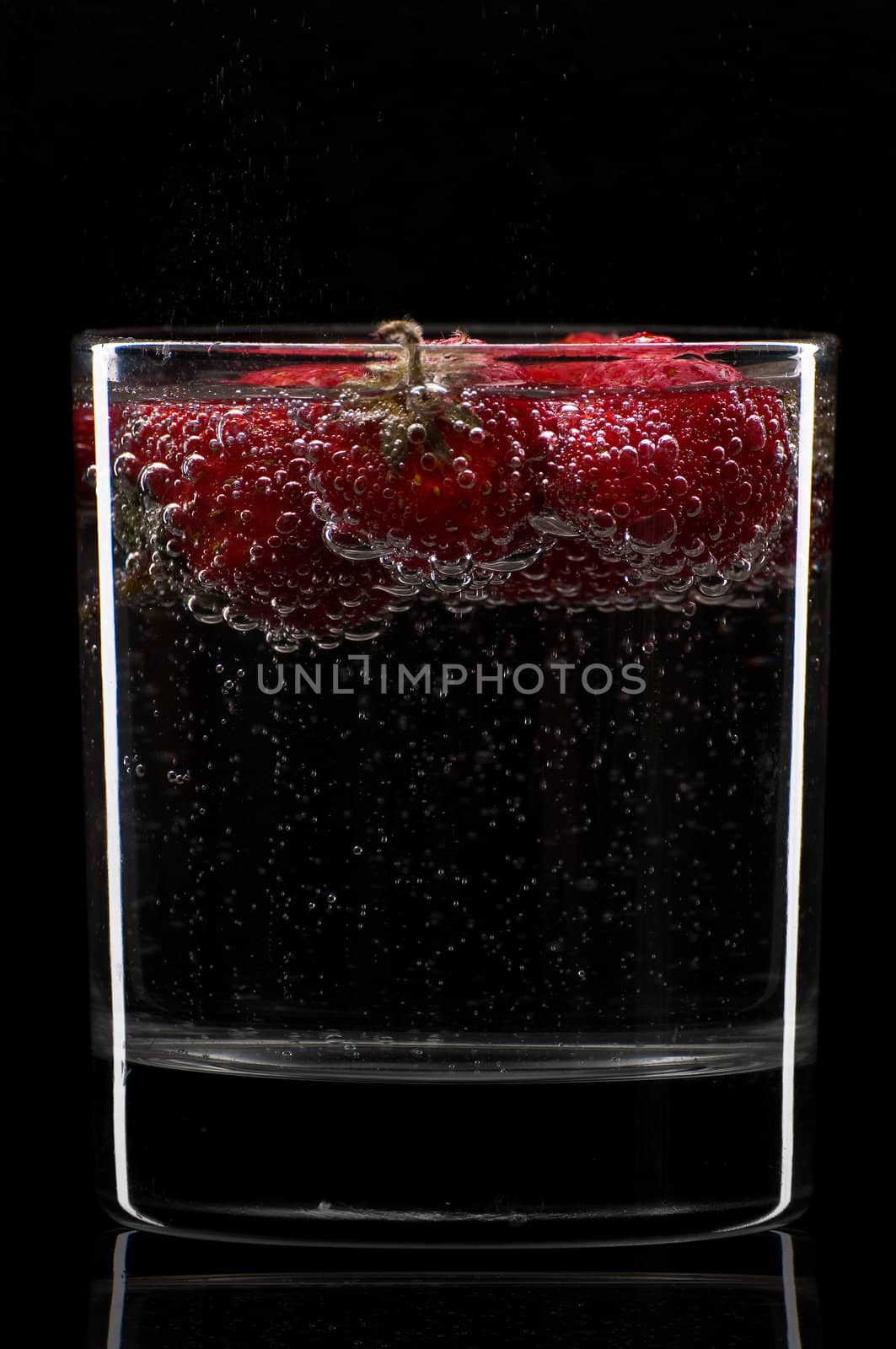 Cocktail with strawberries isolated on black. by Erchog