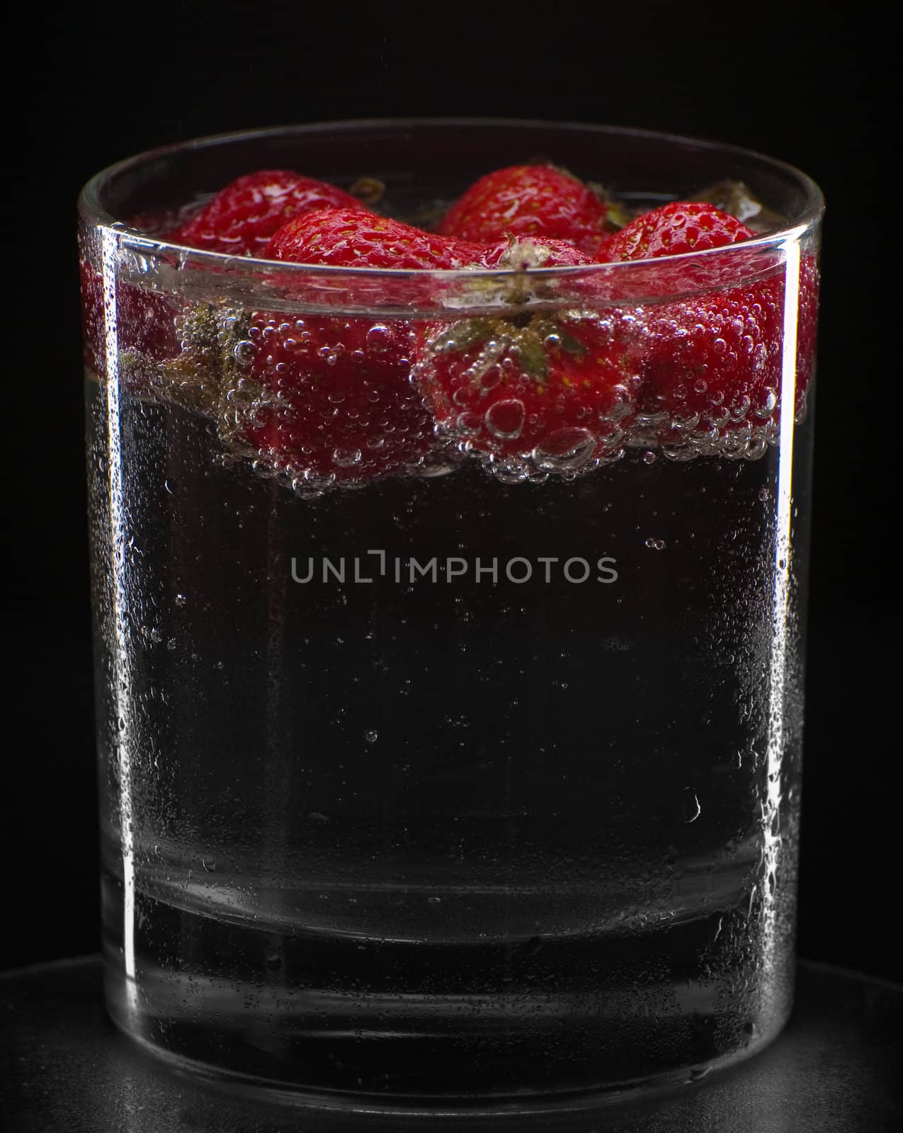 Cocktail with strawberries isolated on black. by Erchog