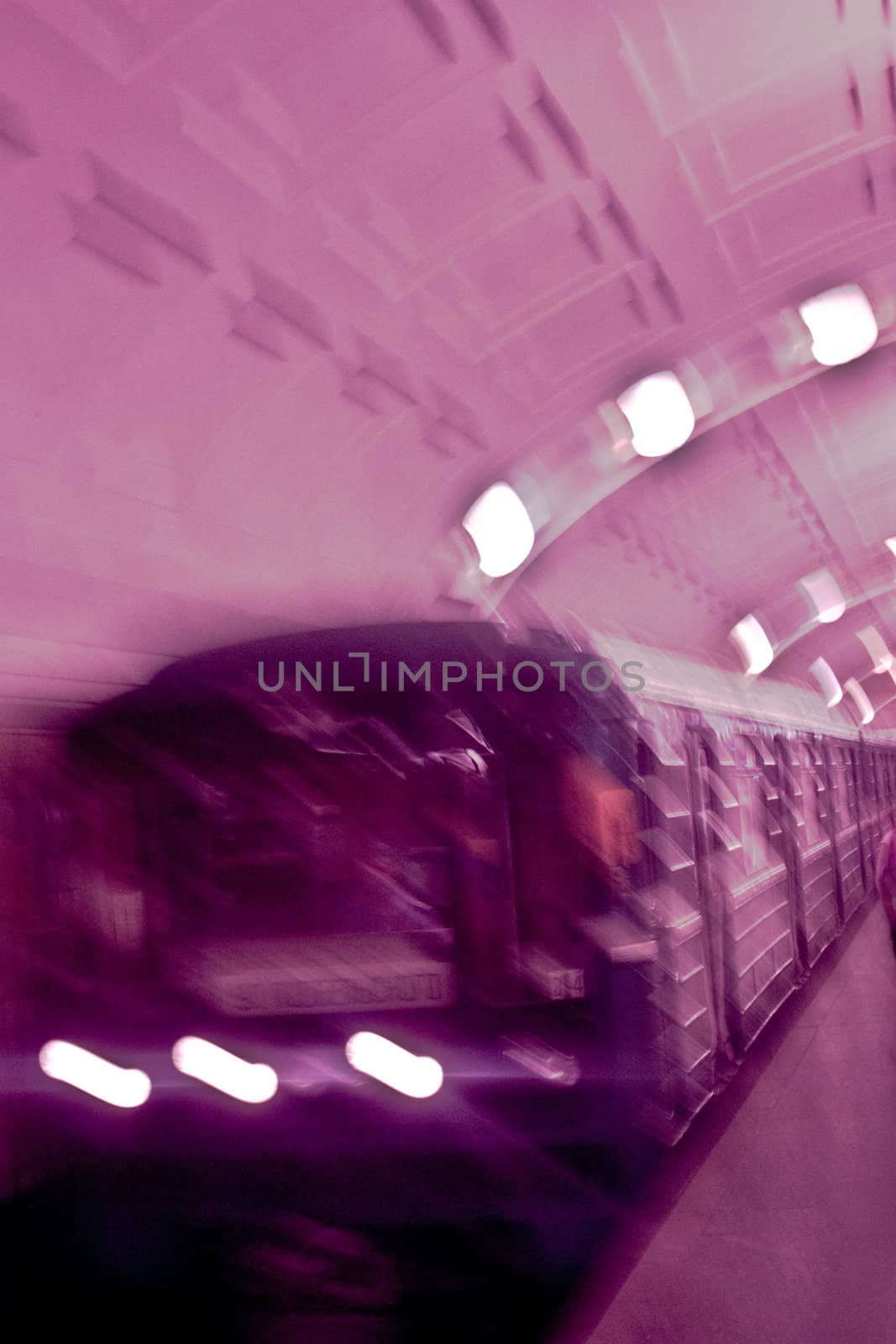 Motion blur of a subway train speeding by a subway passenger platform