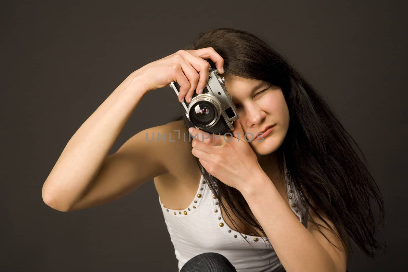 Fashion girl posing with camera isolated on black background