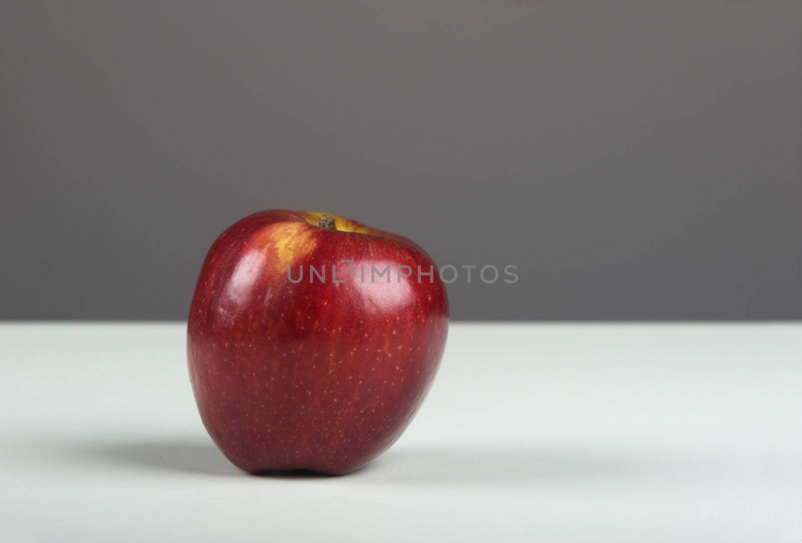 Picture of a healthy apple on a white table