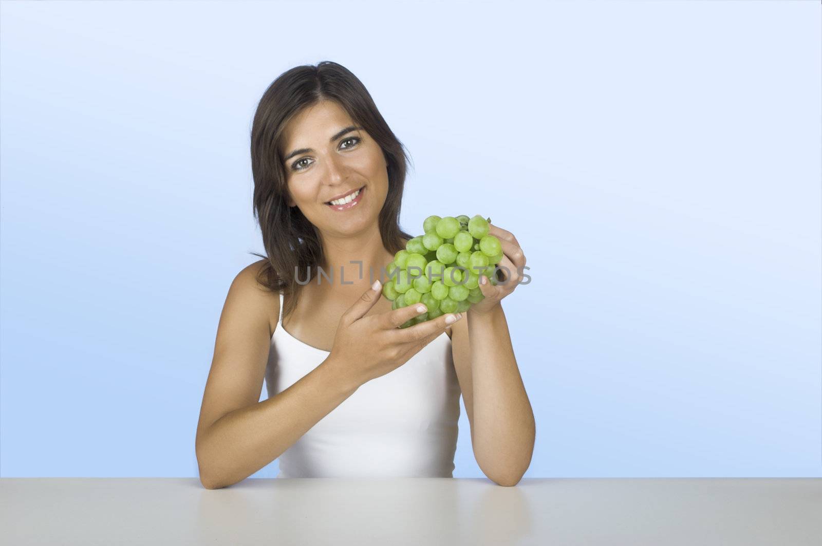 Beautiful young woman holding grapes on her hands