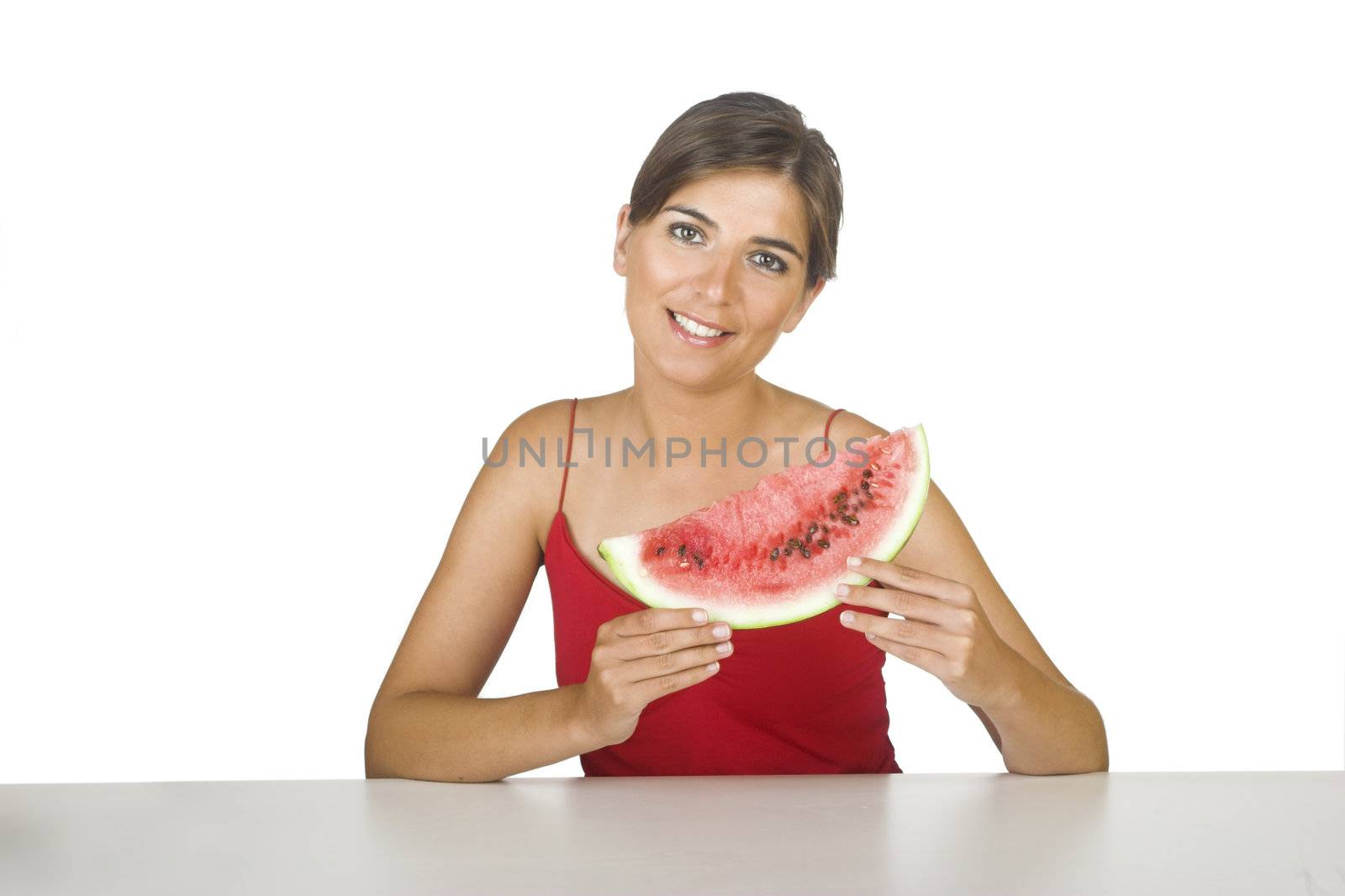 Beautiful young woman in the kitchen holding a watemelon slice