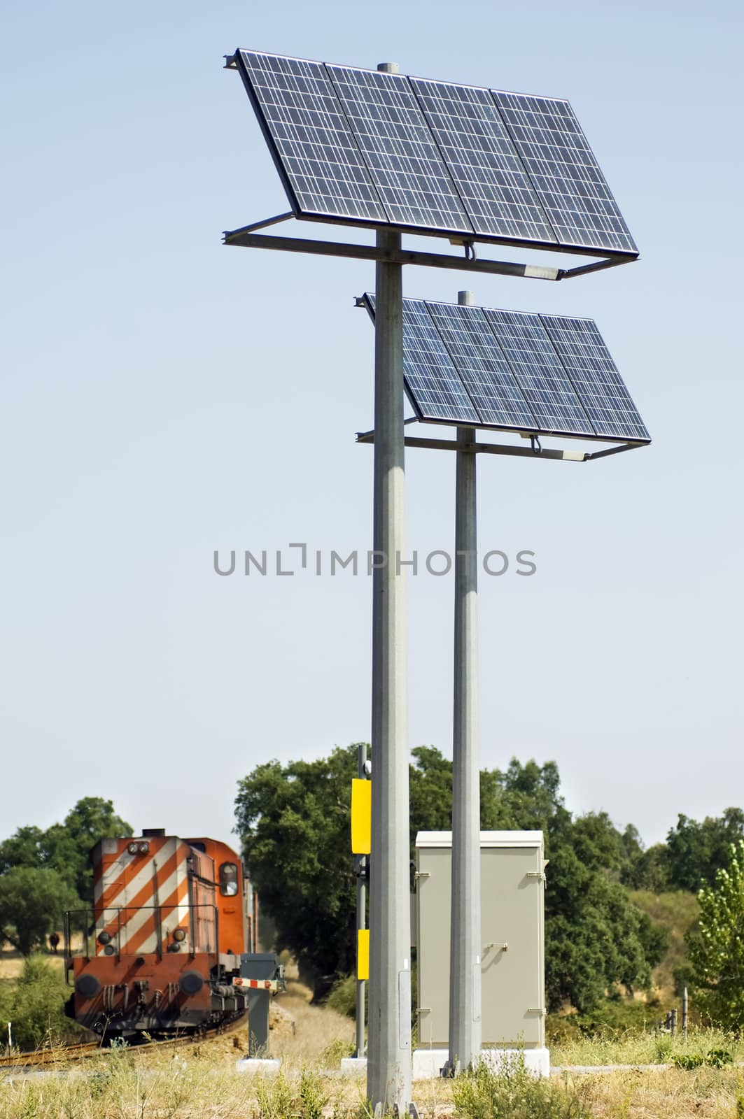 A view of two large solar panels used to power signals and safety equipment associated with a railroad crossing.