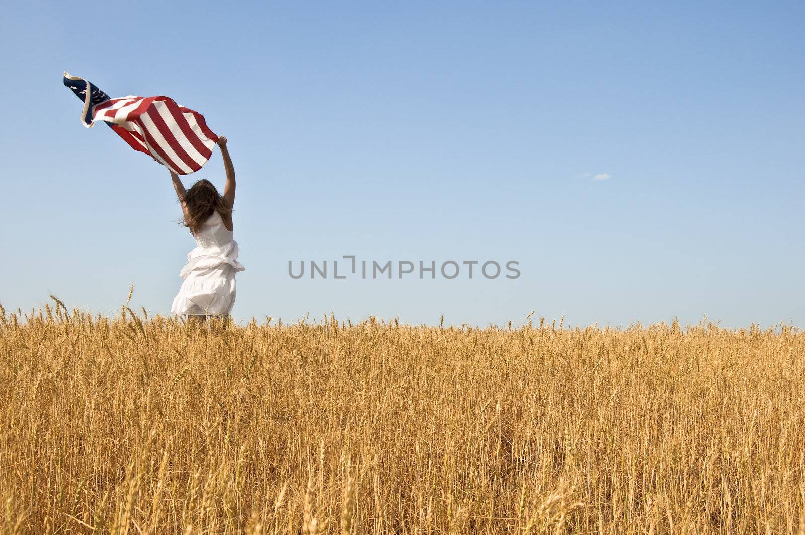 Woman holding a flag in a field of rye. by Oledjio