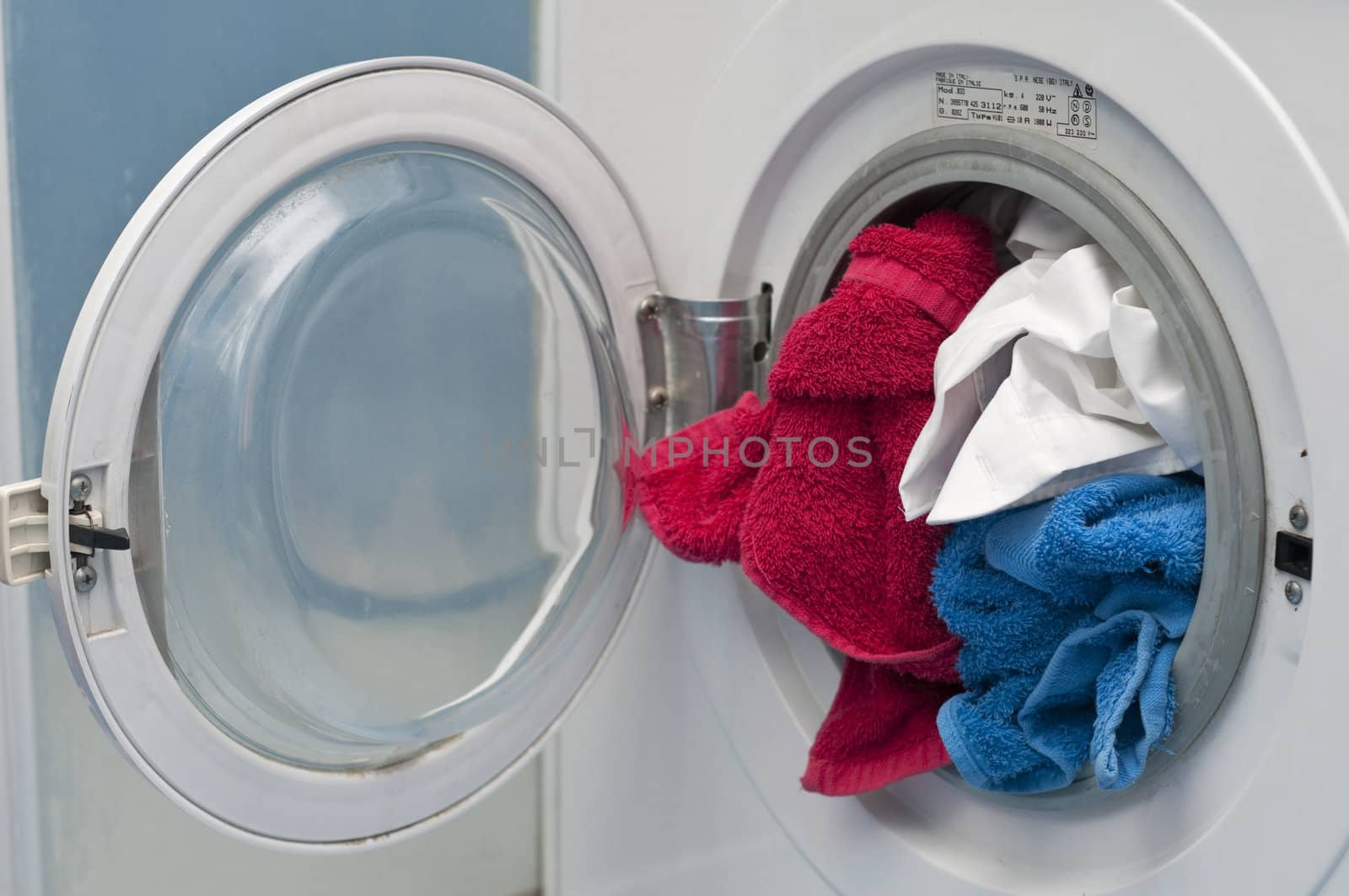 Open Washing machine with white, red and blue cloths