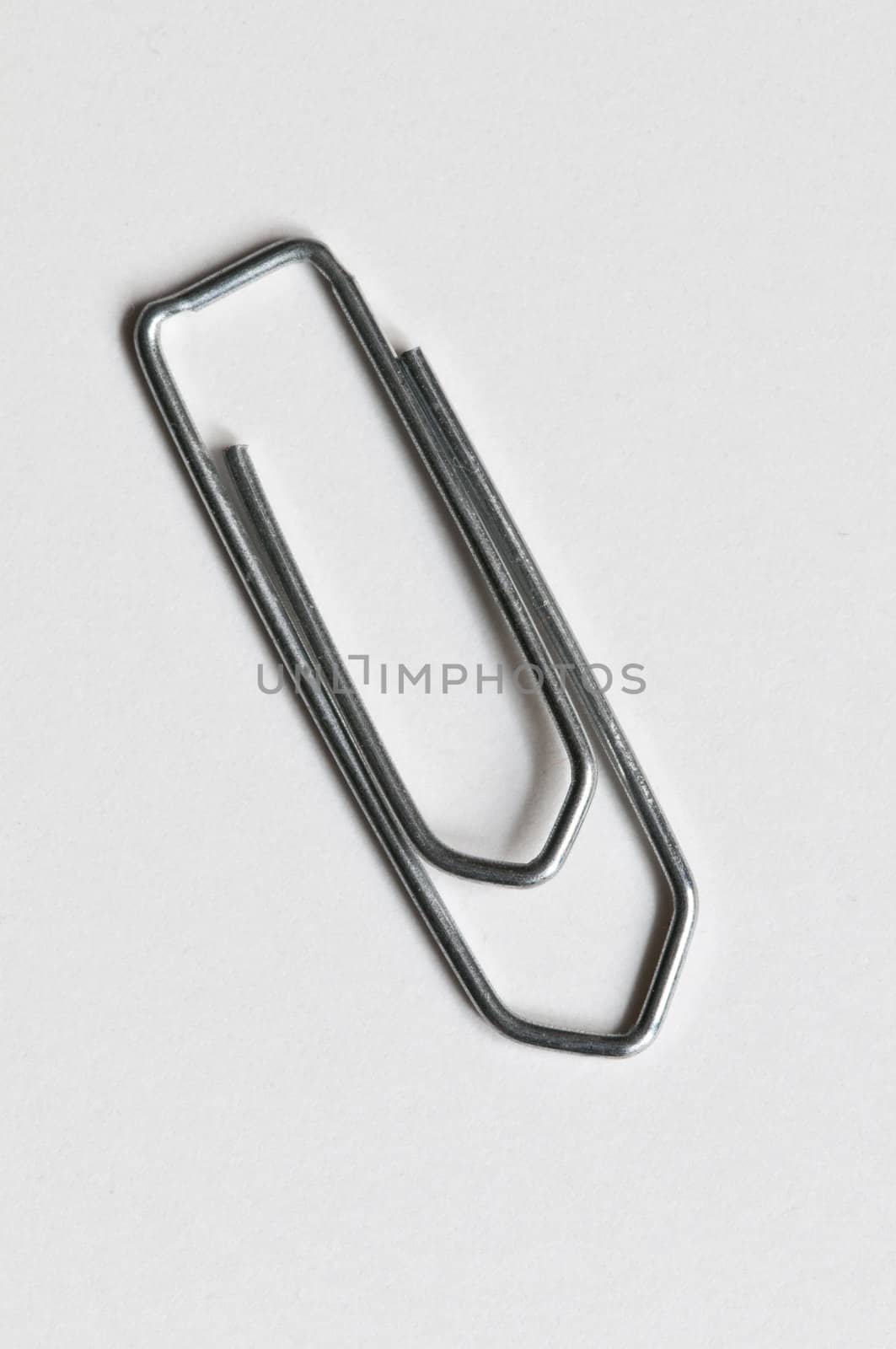 Closeup of a silver paperclip on white background