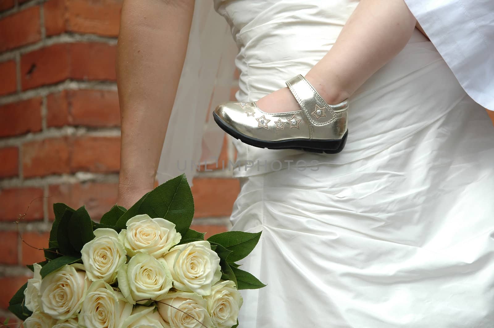 Bride holding her child and flowers.