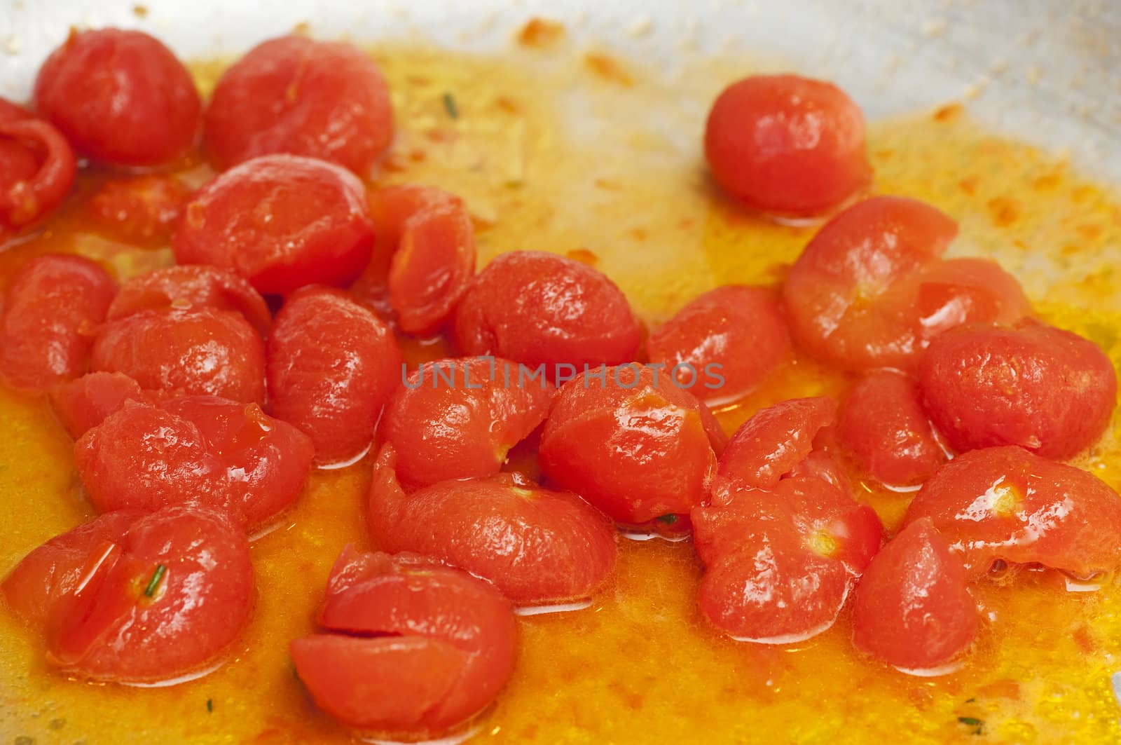 Cooked red cherry tomatoe group in a frying pan