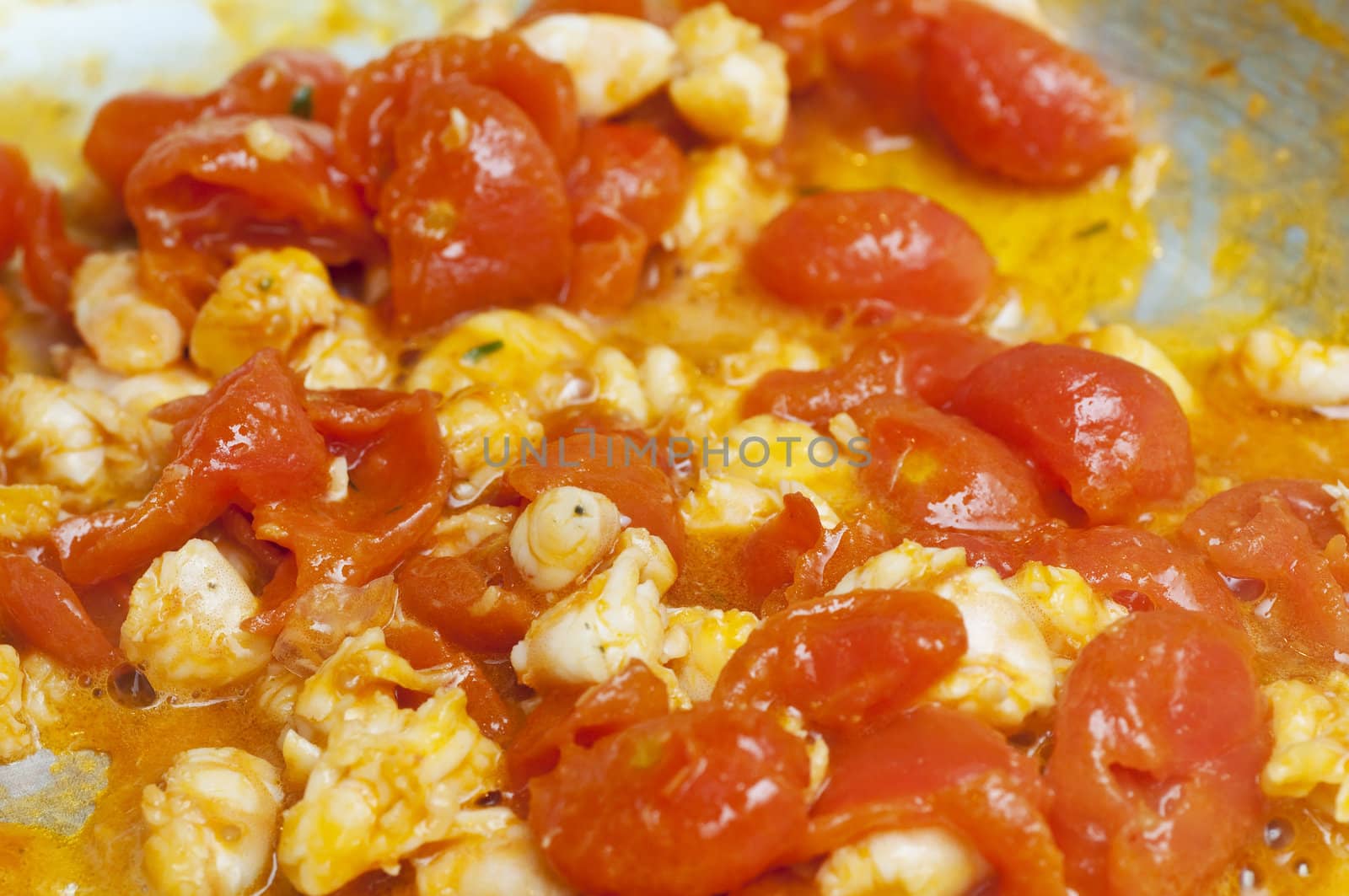 Cooked red cherry tomatoe and shrimps in a frying pan