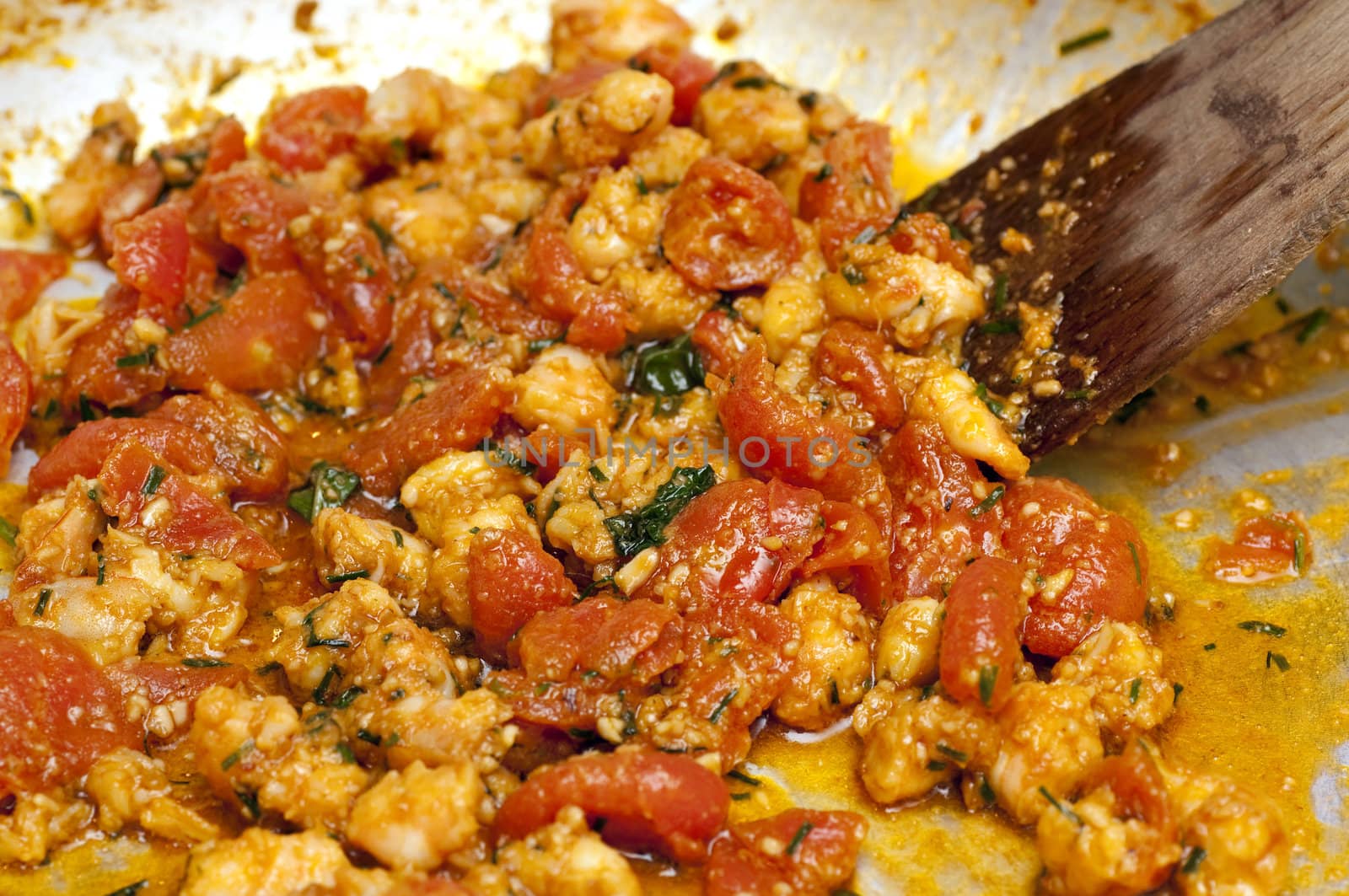 Cooked red cherry tomatoe and shrimps in a frying pan