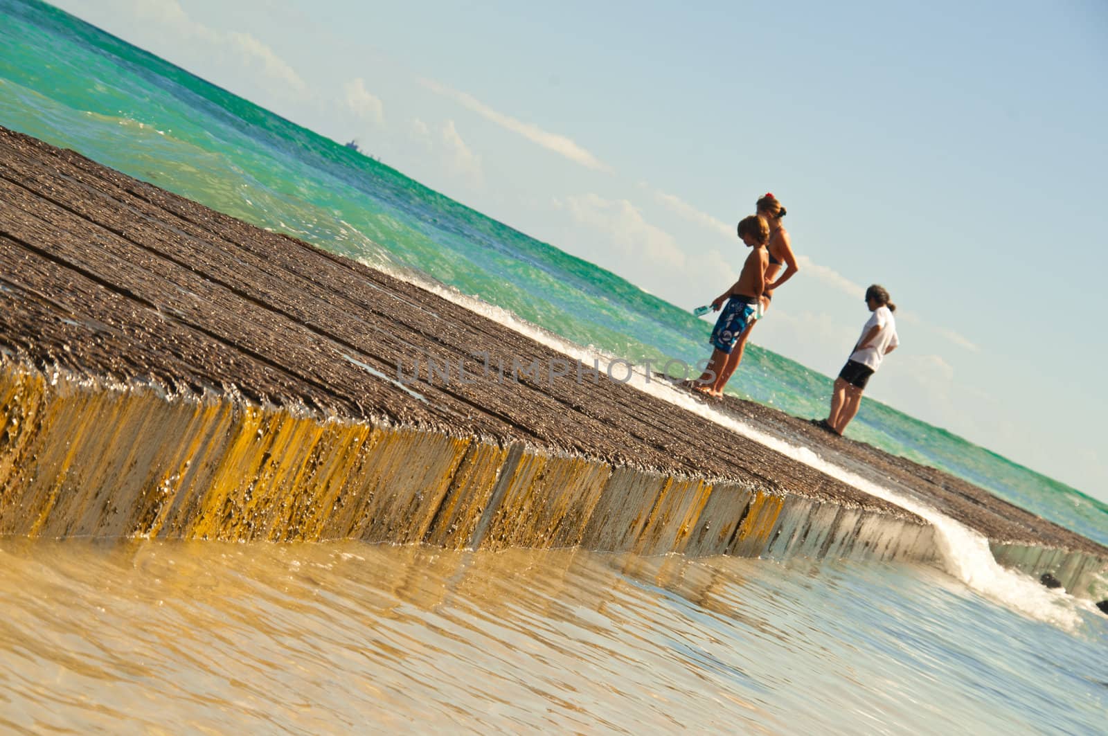 People on a molo watching the ocean life