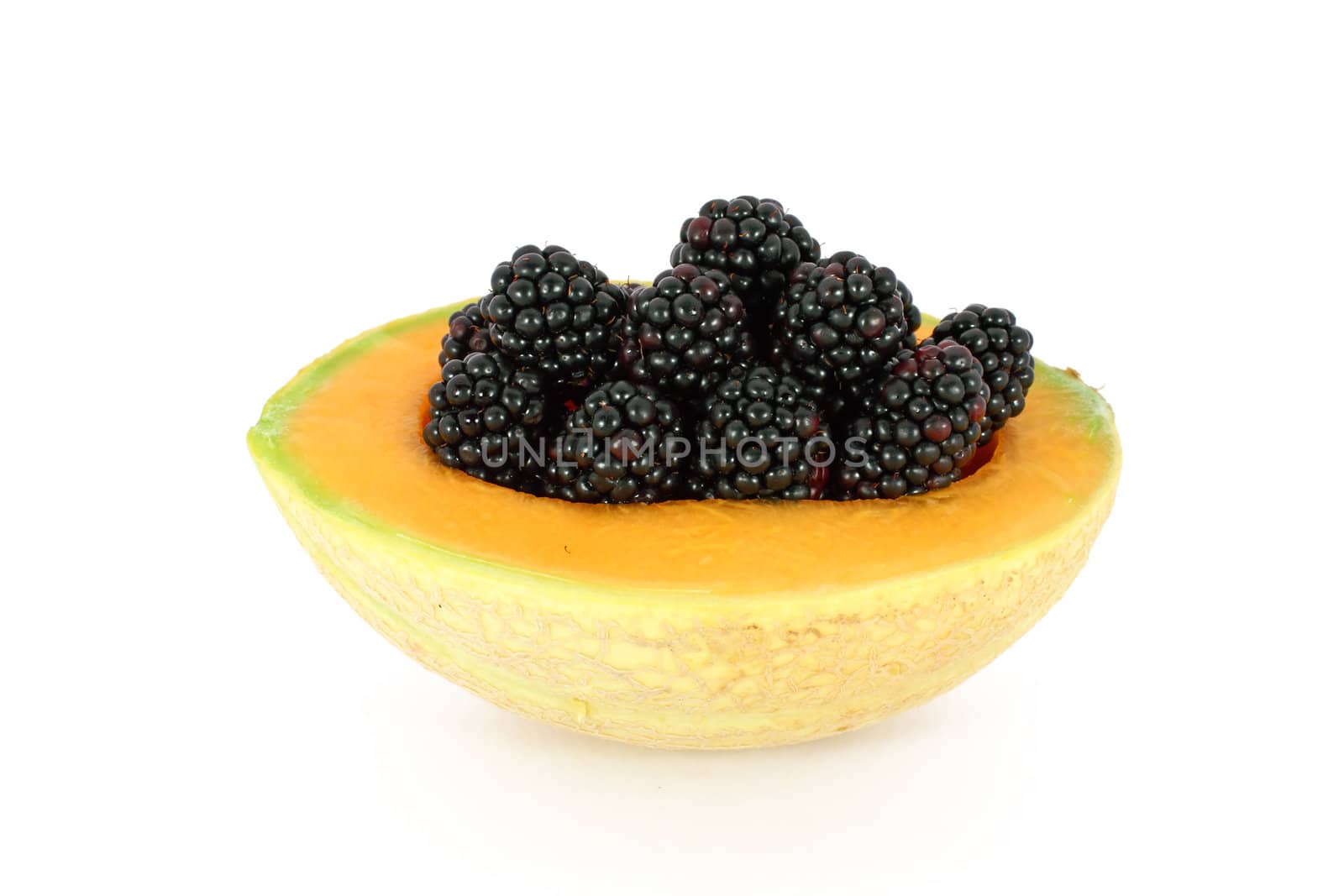Ripe fresh blackberries in melon isolated on white