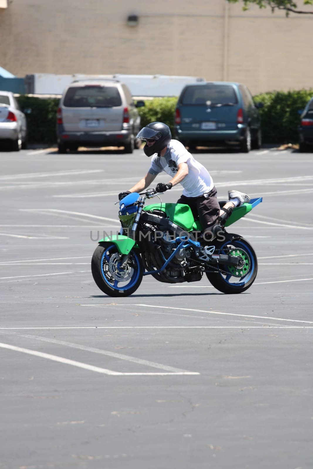 Close up of a motorcyclist on a green motorcycle.