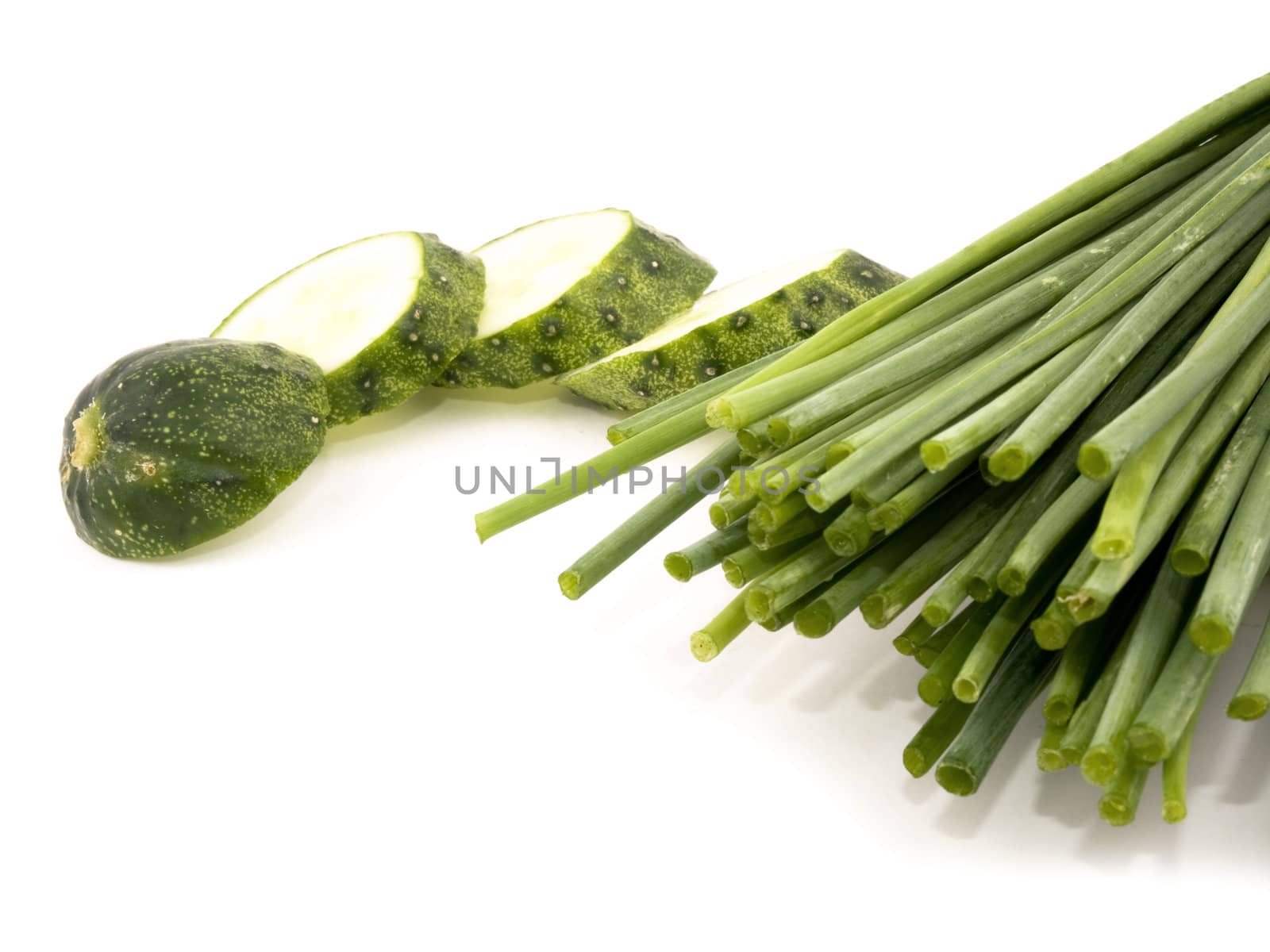 Fresh chives and sliced cucumber on white background