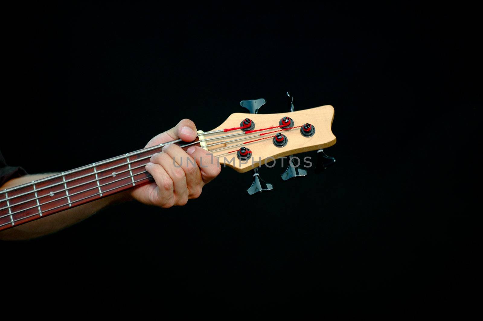 A man is playing his guitar. Taken on a black background.