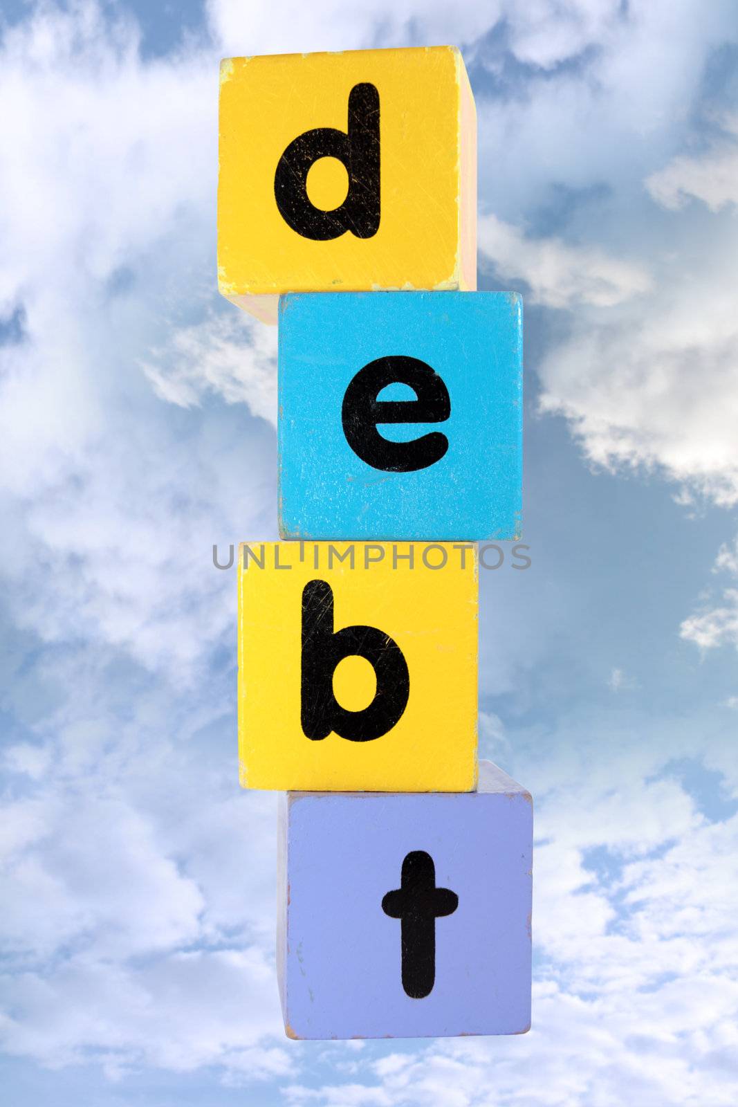 assorted childrens toy letter building blocks against a cloud background that spell debt with clipping path