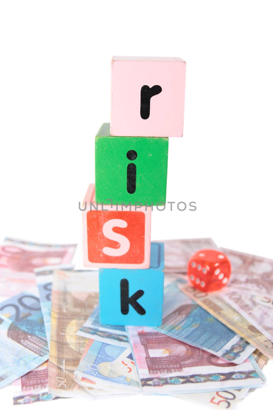 assorted childrens toy letter building blocks and dice against a white background on money that spell risk