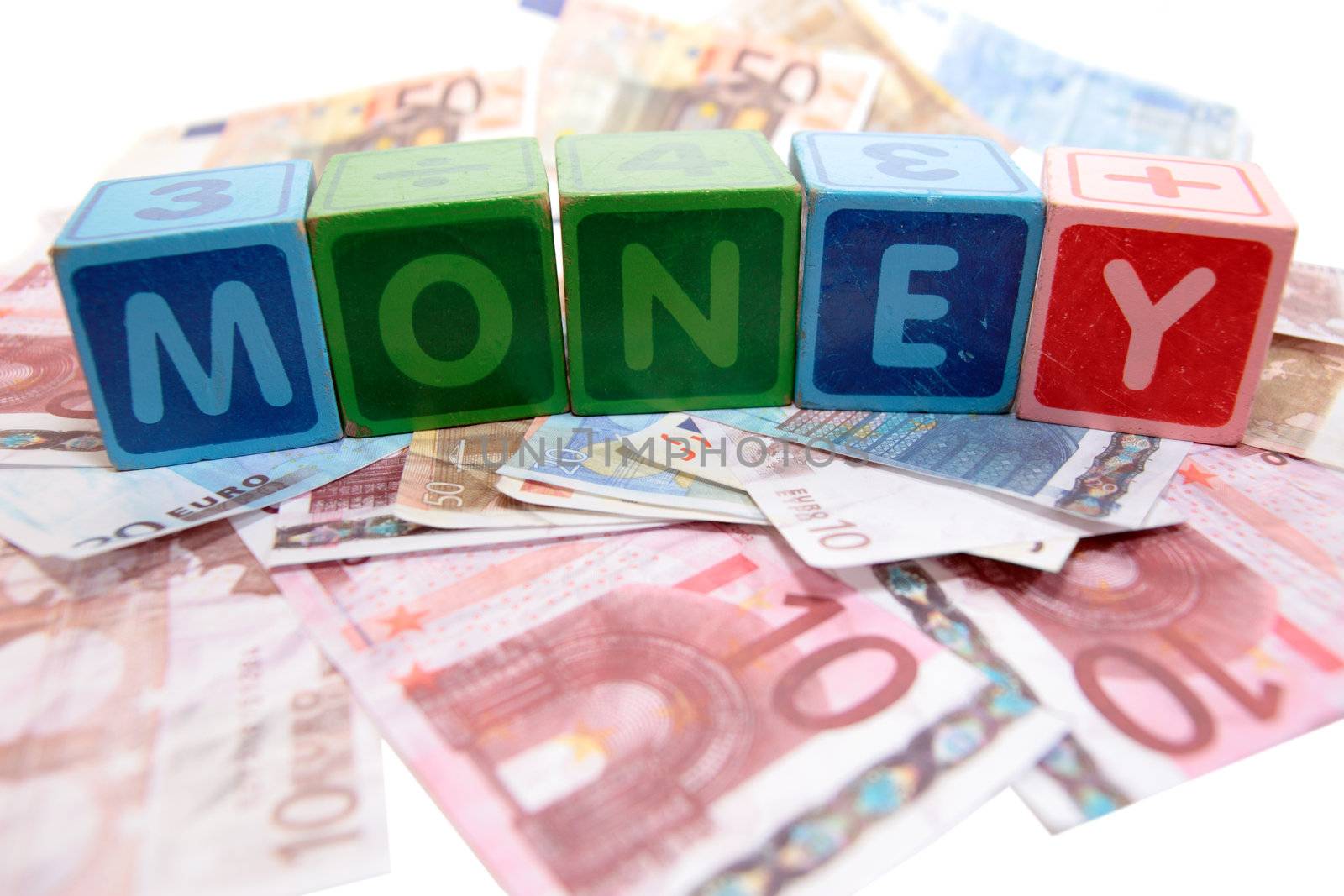 assorted childrens toy letter building blocks against a white background on money that spell money