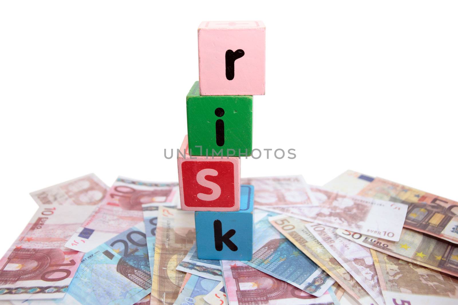 assorted childrens toy letter building blocks against a white background on money that spell risk