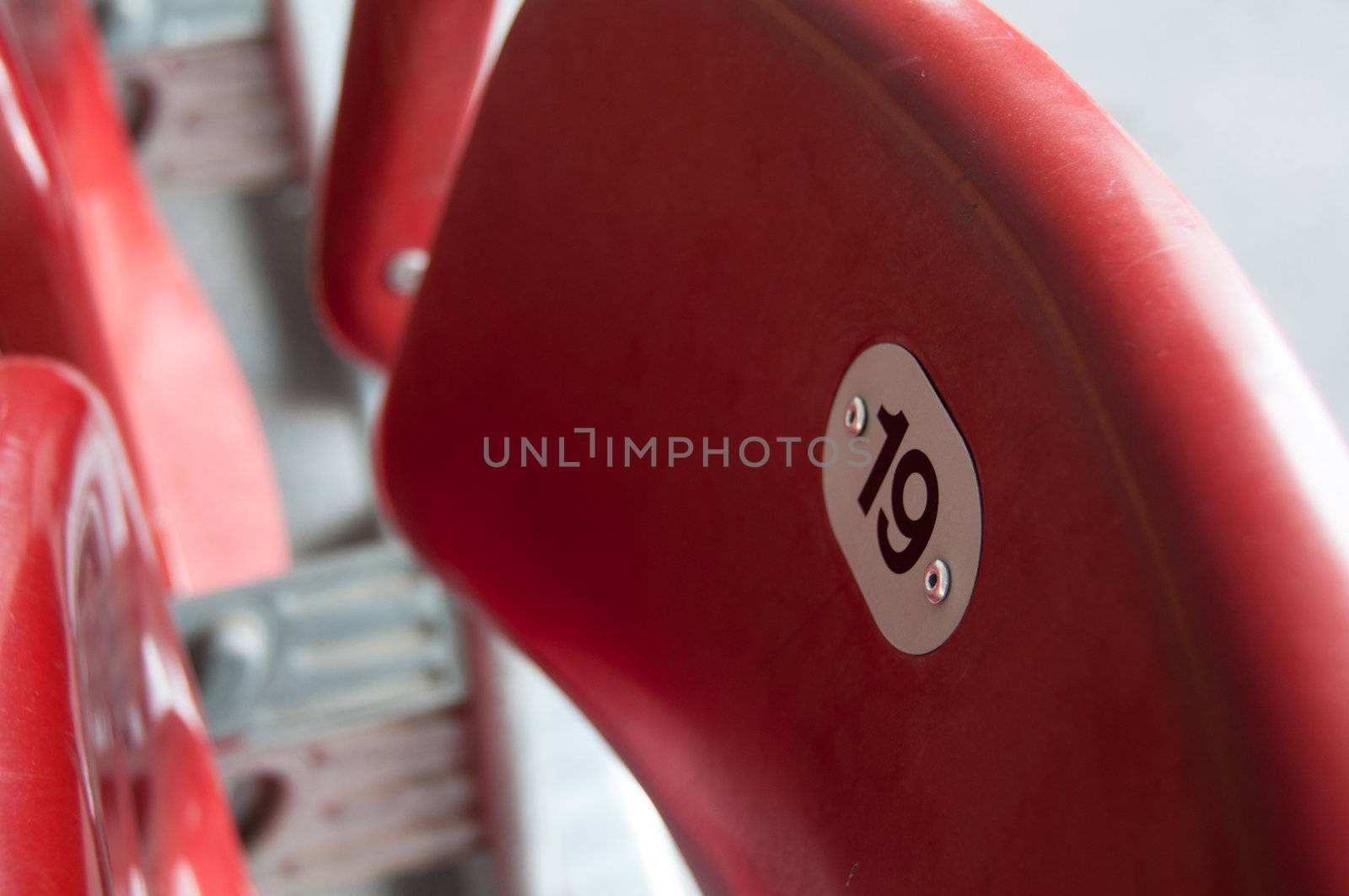 Rows of empty red seats in a football stadium