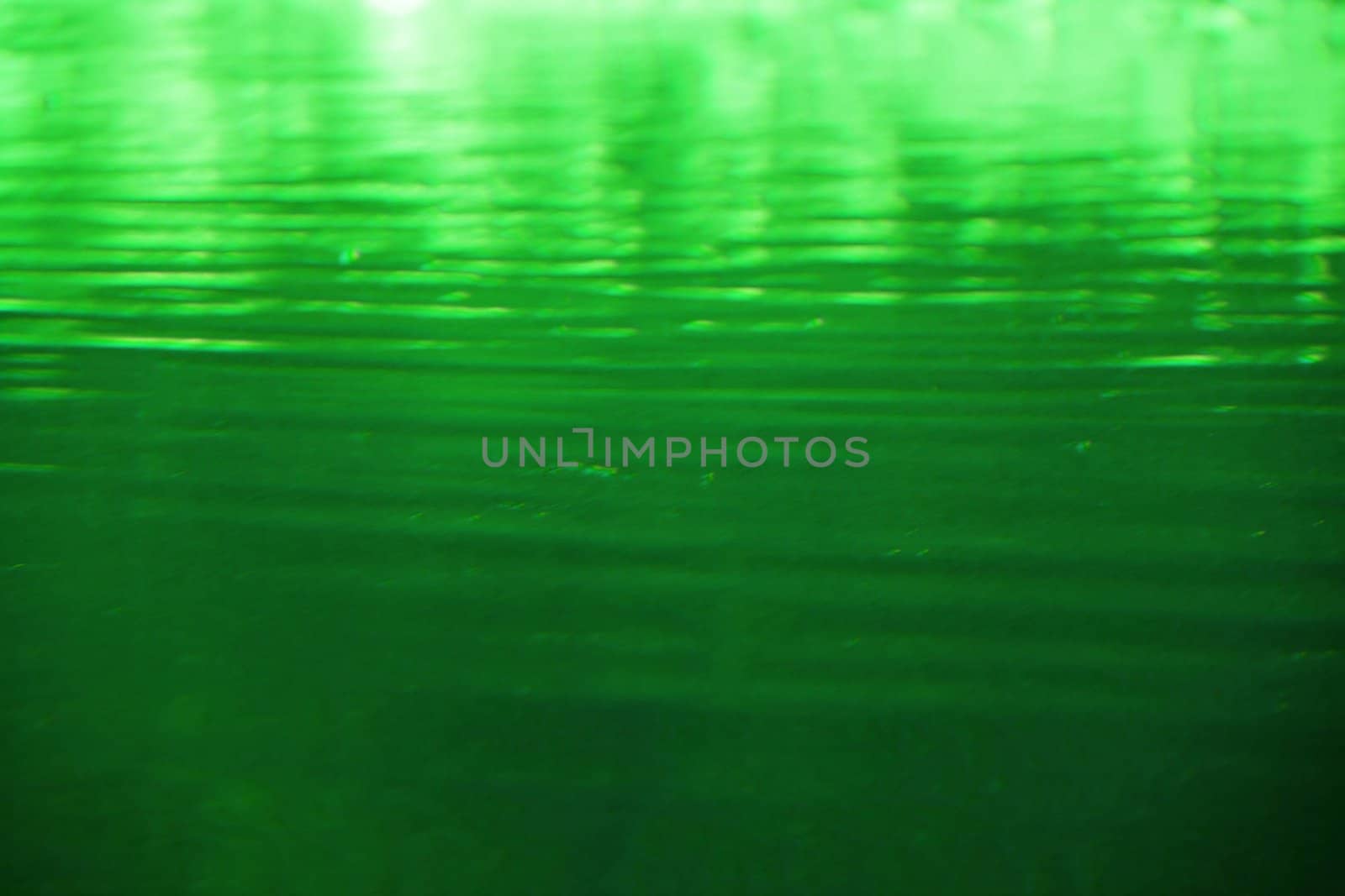 Abstract green liquid with waves and getting lighter in the distance.