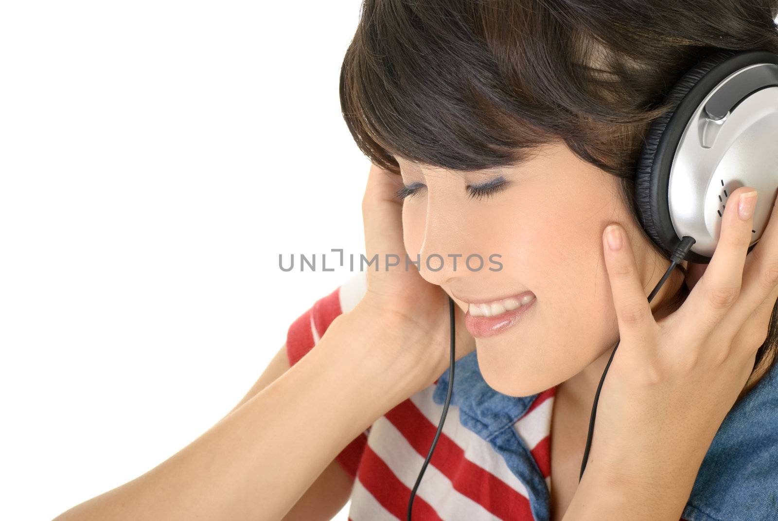 Happy girl listen music by earphone, closeup portrait with copyspace on white background.