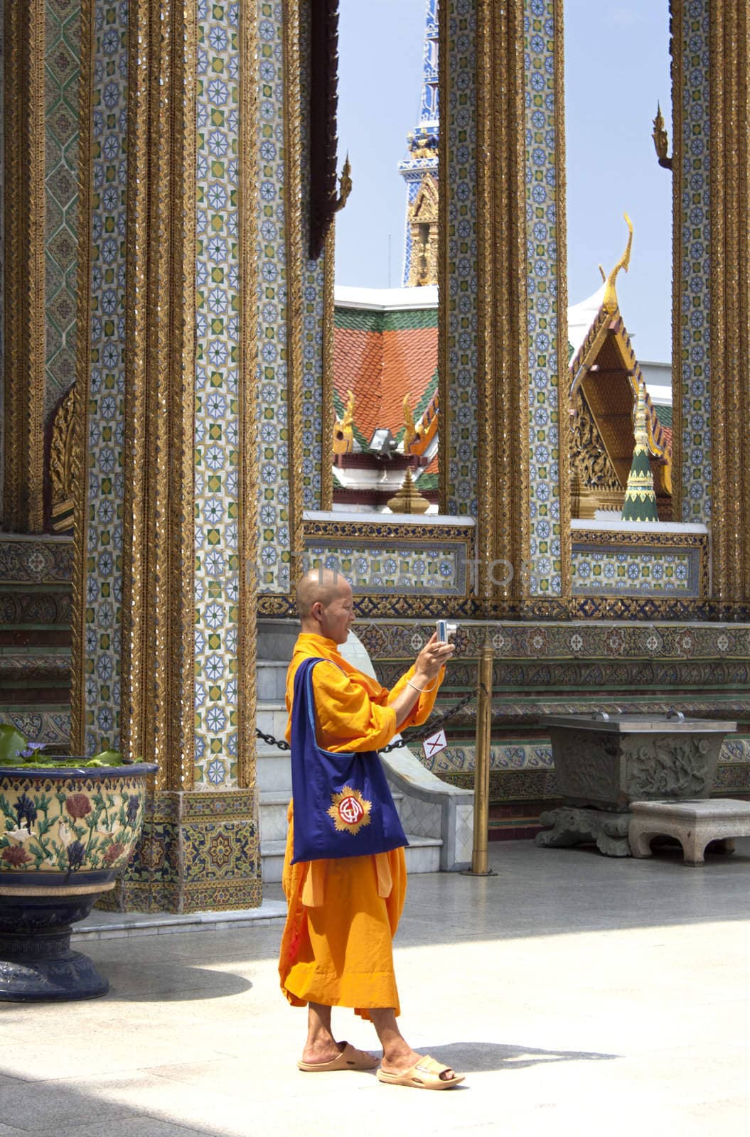 Monk in the Grounds of the Grand Palace taking a photo. 