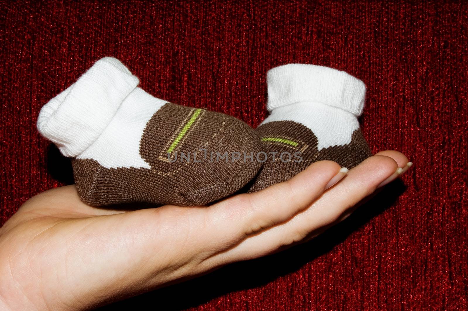 Children's shoes on palm of mother 