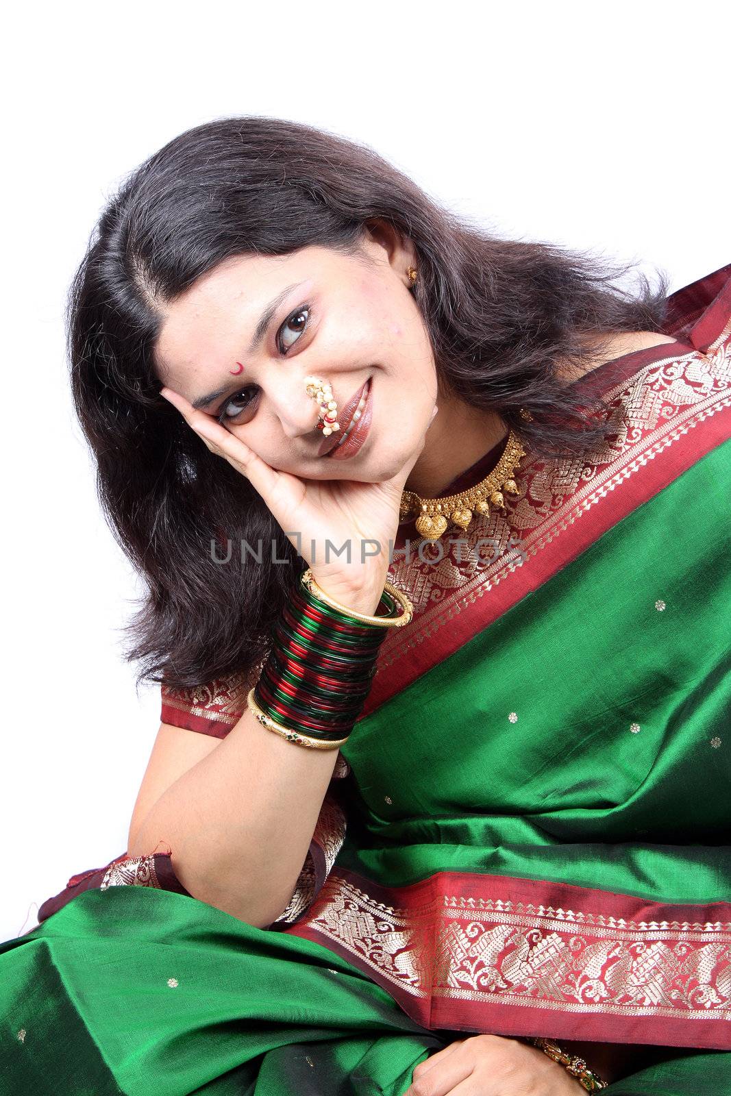 A beautiful Indian woman dressed up in a green sari and gold jewelery on the occassion of Diwali festival in India.