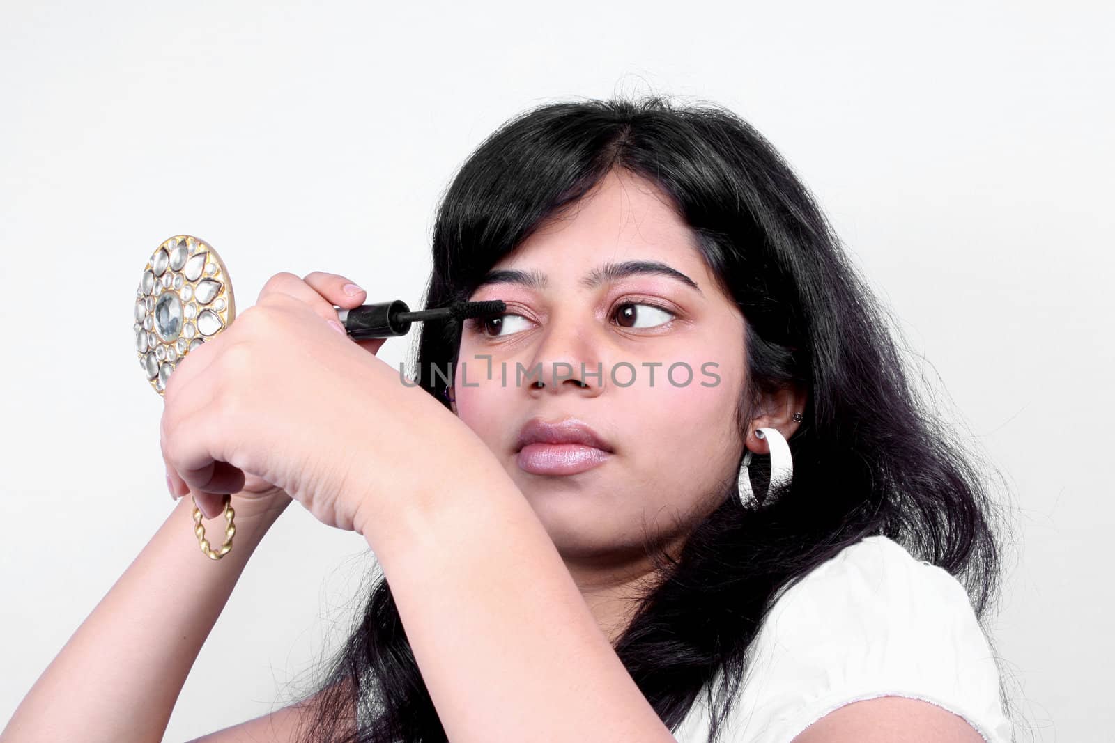 A beautiful Indian teenage girl wearing eye mascara.