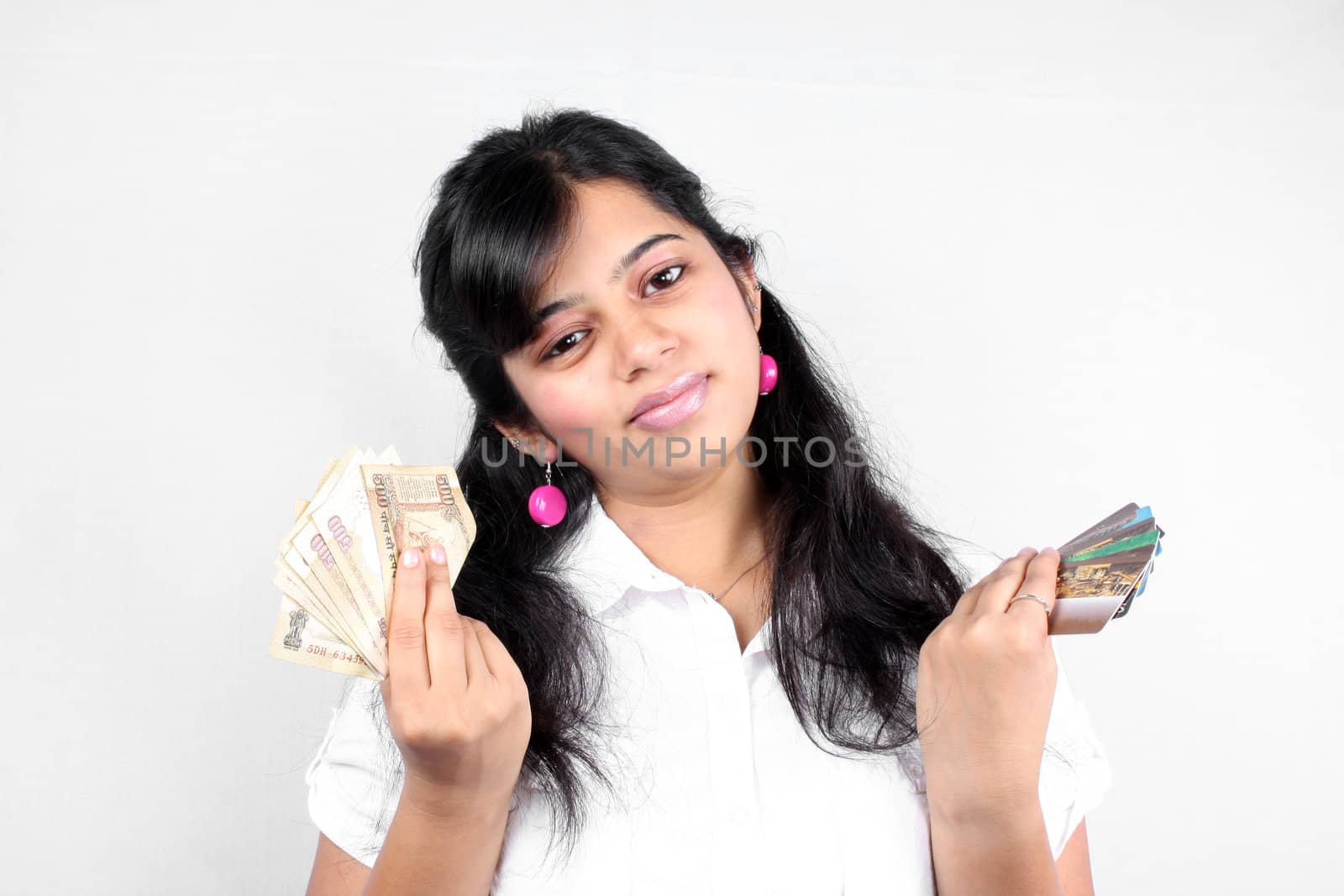 A rich Indian girl showing off her cash (Indian currency) and many credit cards.