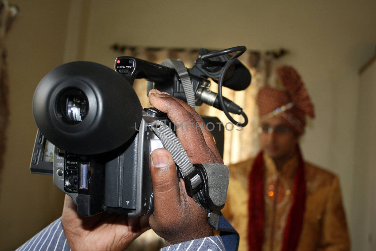 A view of a video camera shooting a traditional Indian wedding groom.