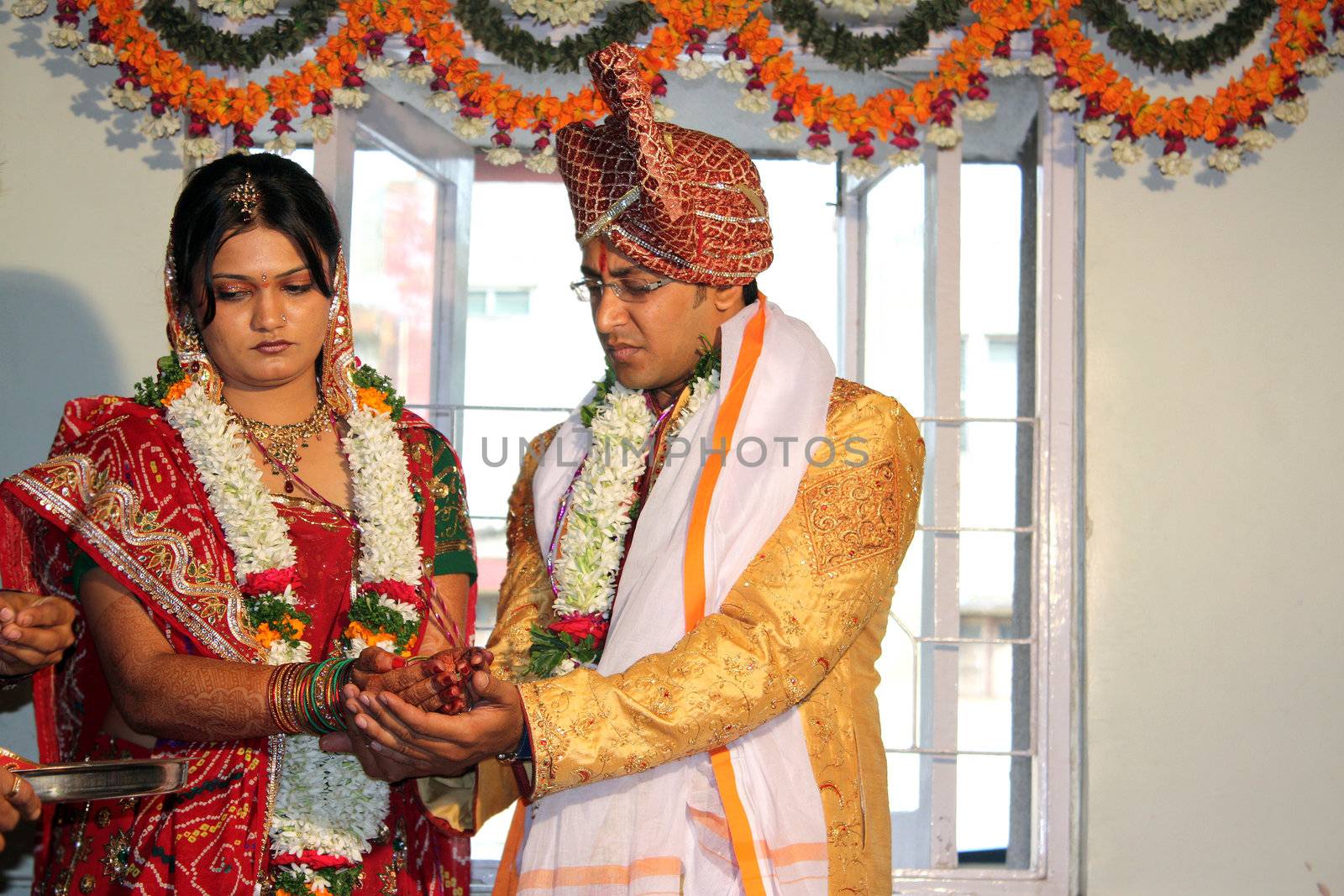 A hindu groom and bride in a traditional wedding ritual, in India.