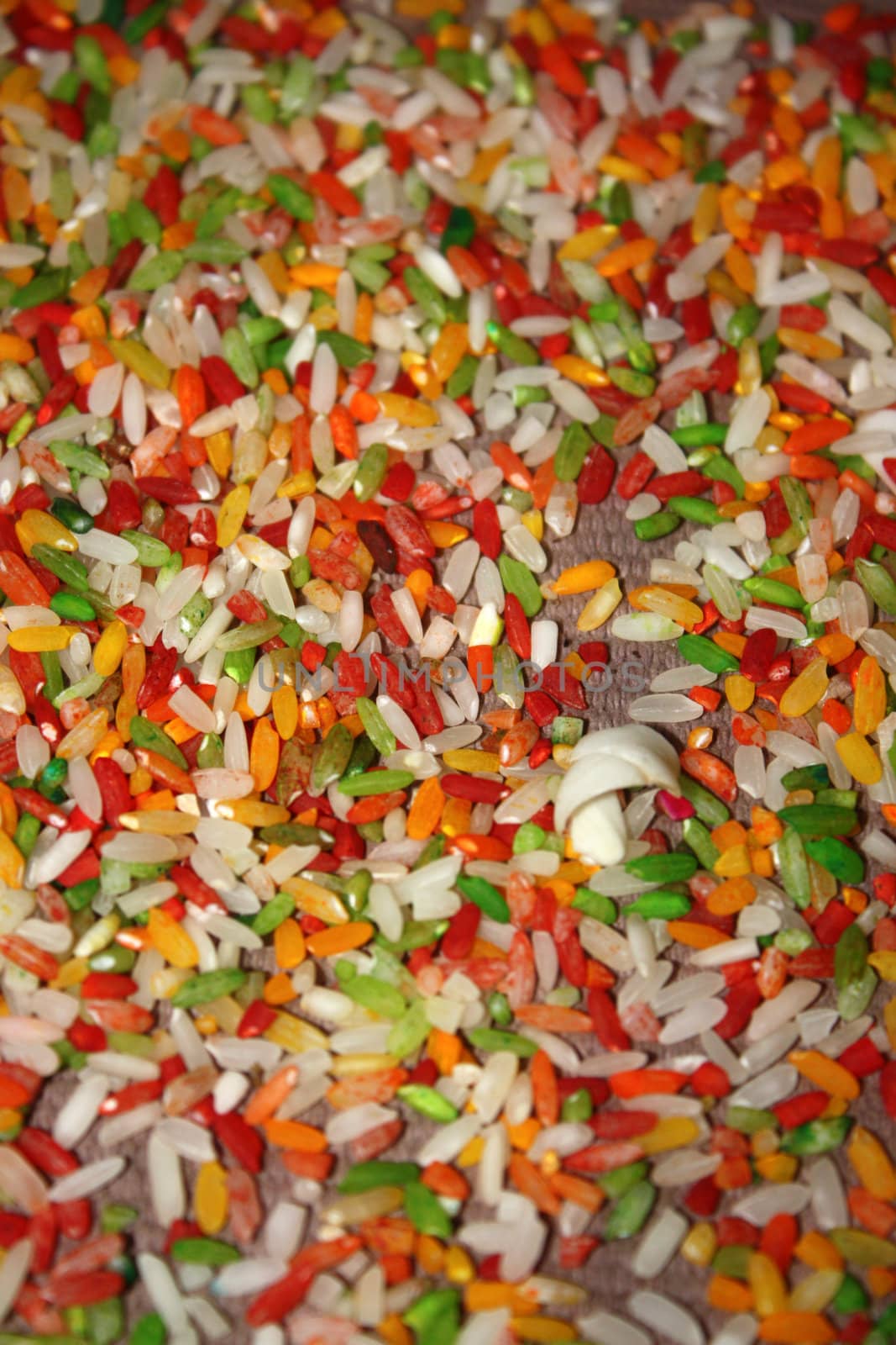 A background of colorful rice grains used in hindu rituals.