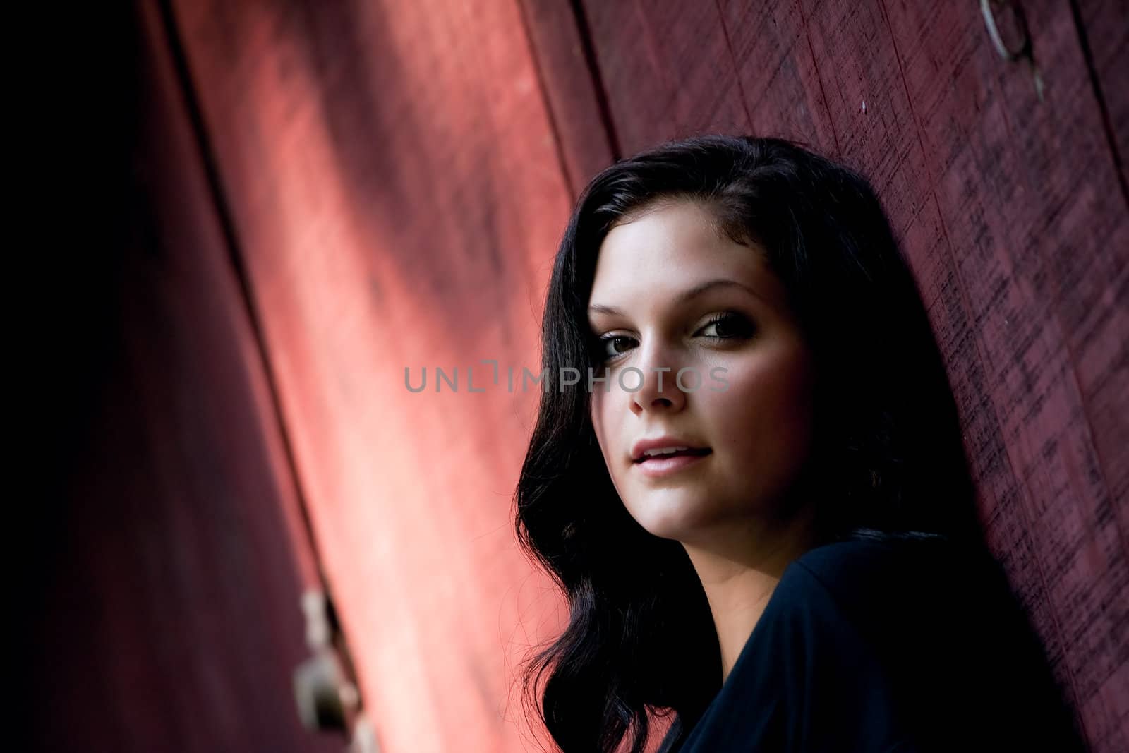 An attractive young woman in her twenties posing in a rustic country setting.