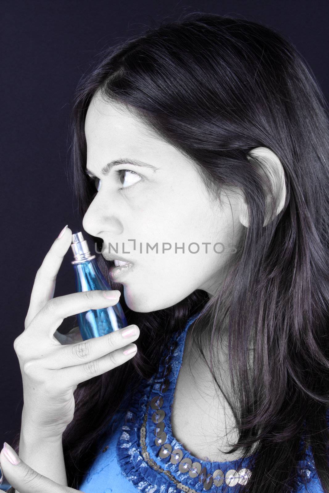 A portrait of a beautiful Indian teenage girl choosing a perfume.