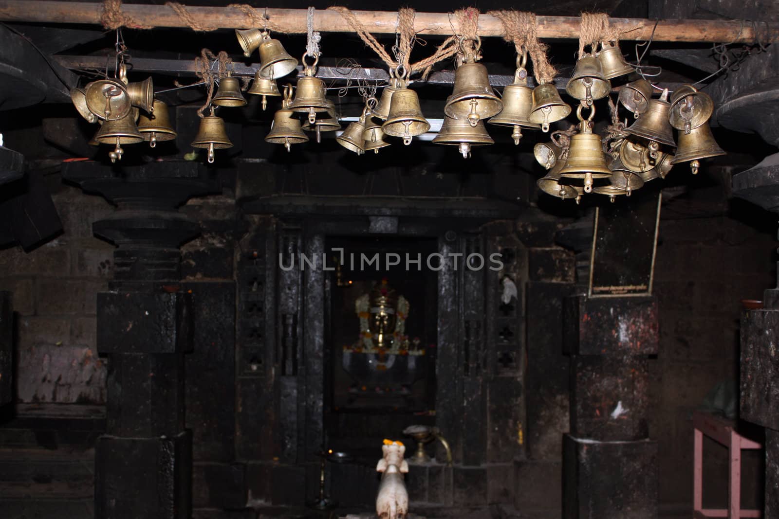 Many bells hanging in an ancient hindu temple in India.