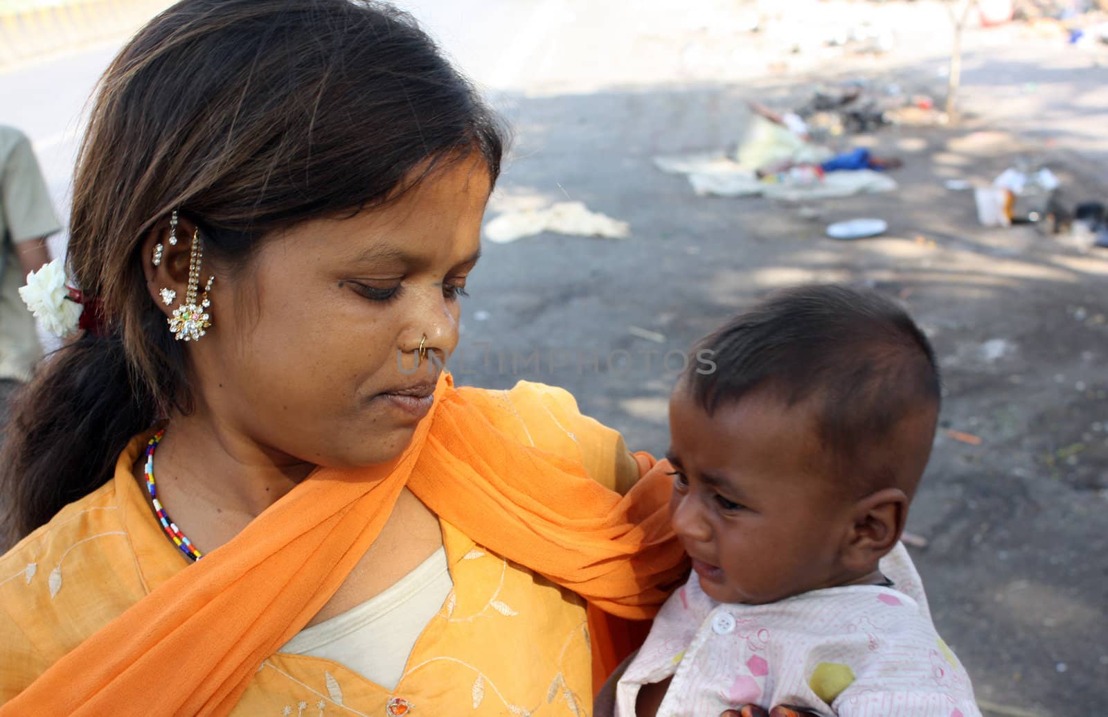 Teenage marraiges are not legal and is one of the important crime happening since many years in India. Seen here is a young mother with a child. Focus on the eye of the mother.