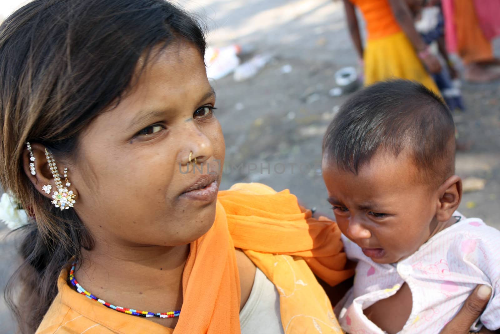 Teenage marraiges are not legal and is one of the important crime happening since many years in India. Seen here is a young mother with a child. Focus on the eye of the mother.