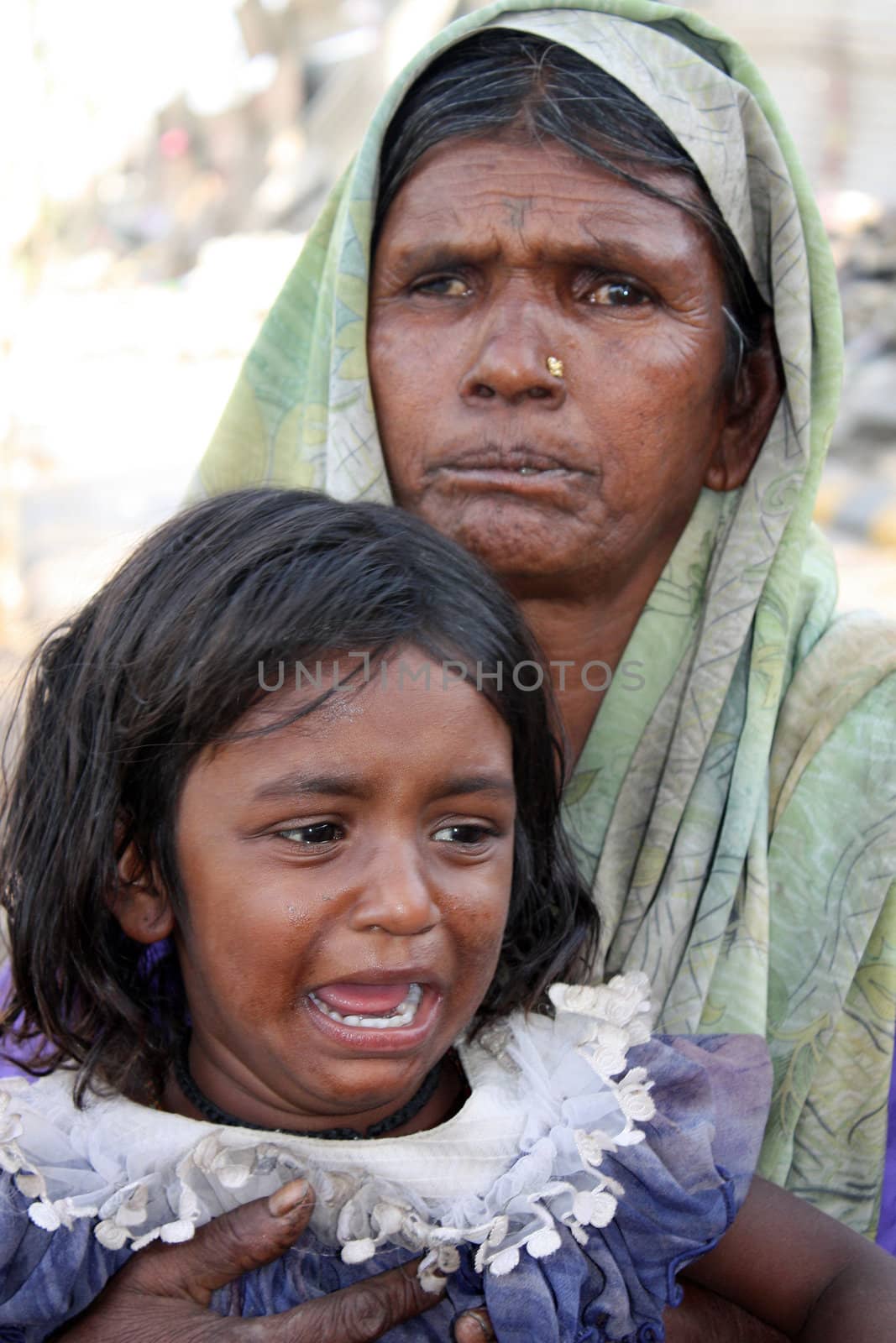 A portrait of a crying daughter with her grandmother in poor parts of India.