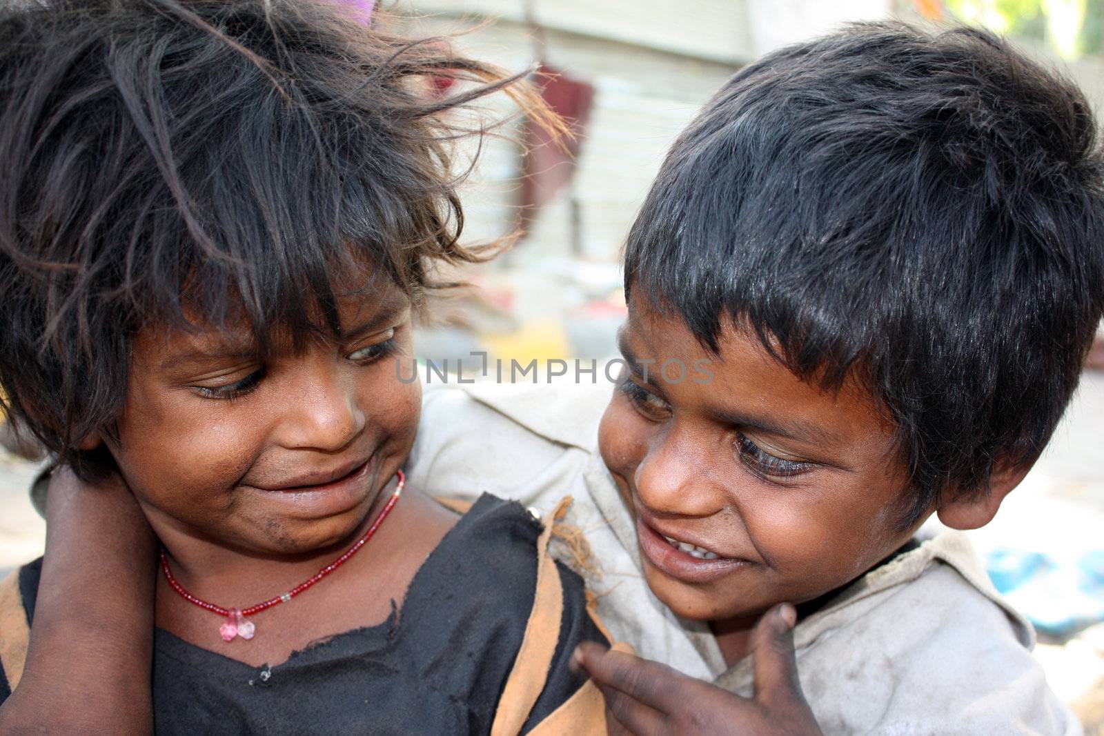 A portrait of cute happy siblings living in the poor parts of India and making a living out of begging.