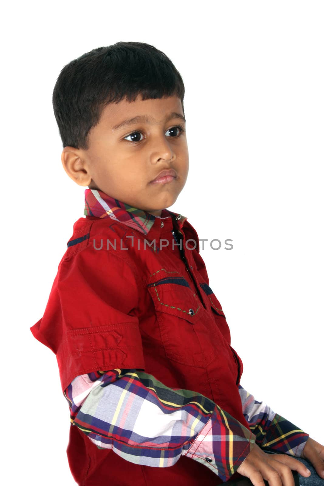 A portrait of an Indian boy in a unhappy mood, on white studio background.