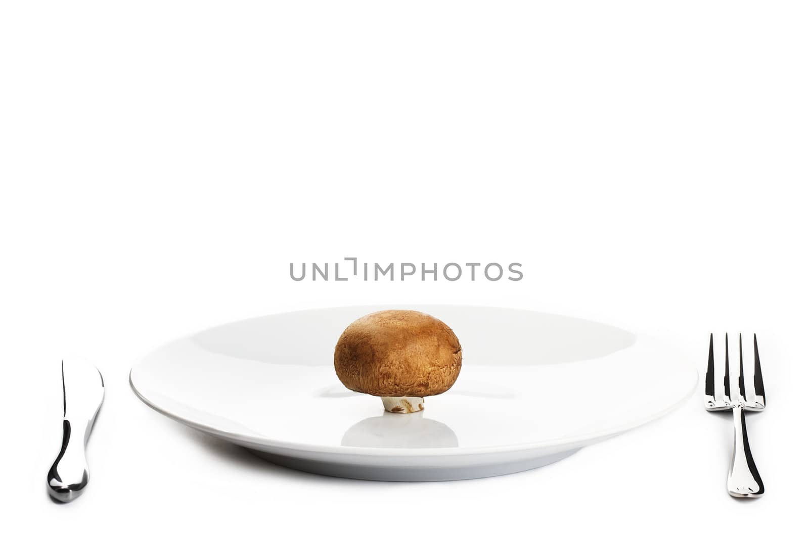 brown mushroom on a plate with knife and fork