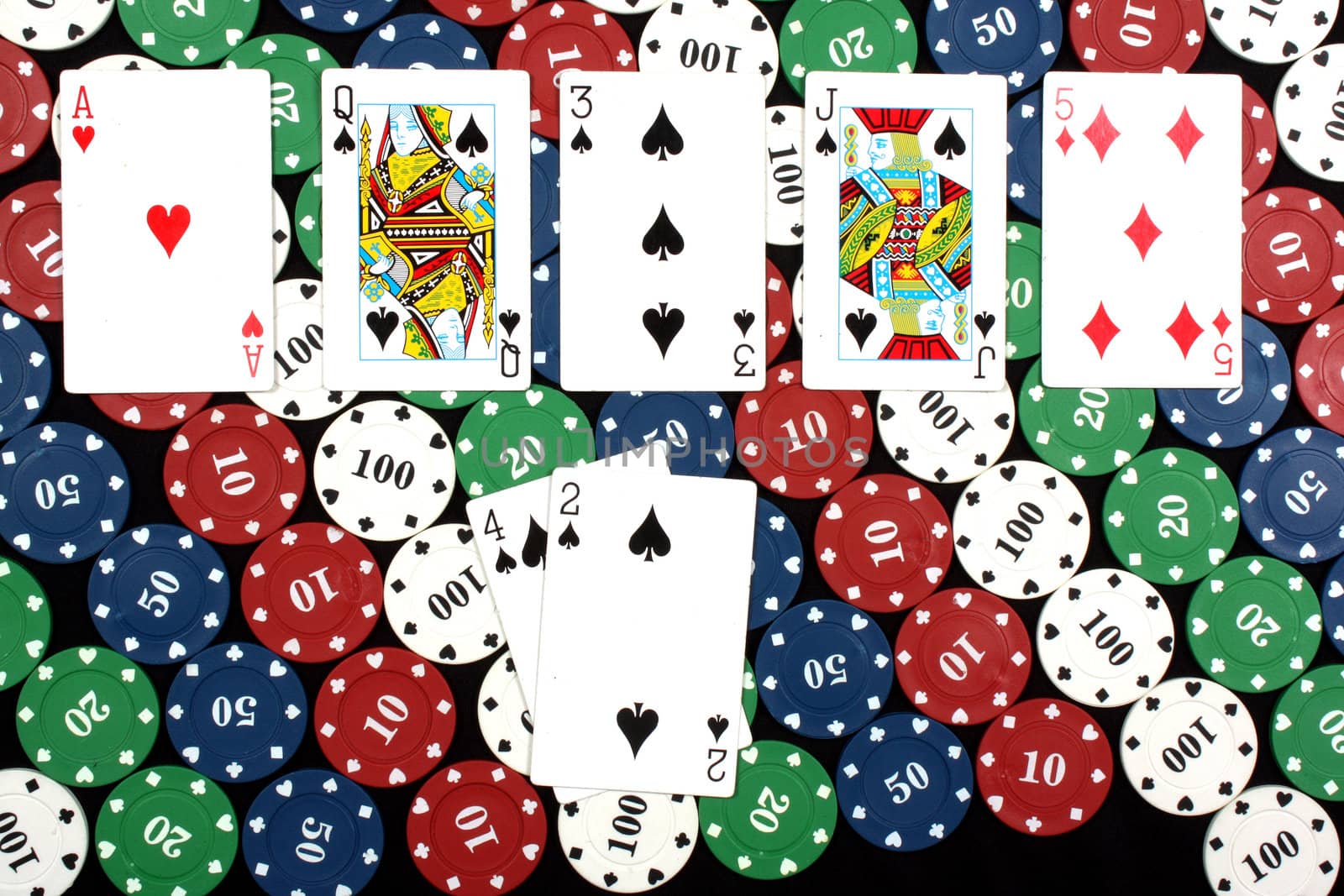 A winning hand of poker called flush containing 5 cards of the same deck (spades in this case), on colorful gambling chips.