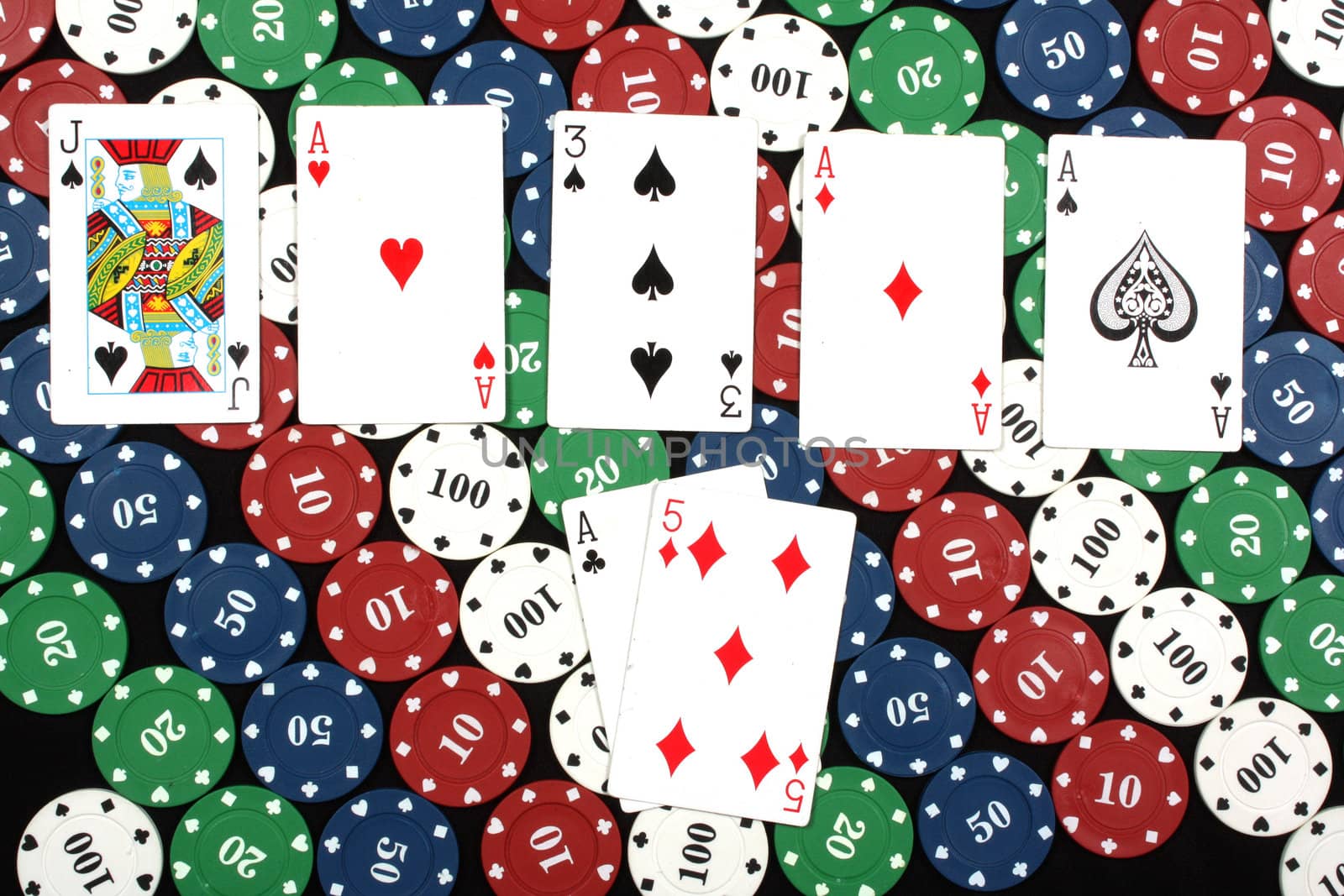 A poker winning hand of four of a kind having four aces, on colorful poker chips.