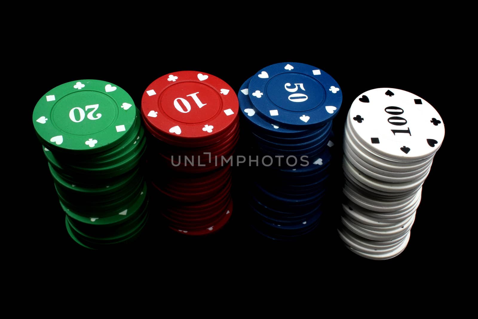 Stacks of colorful gambling chips, isolated on black studio background.