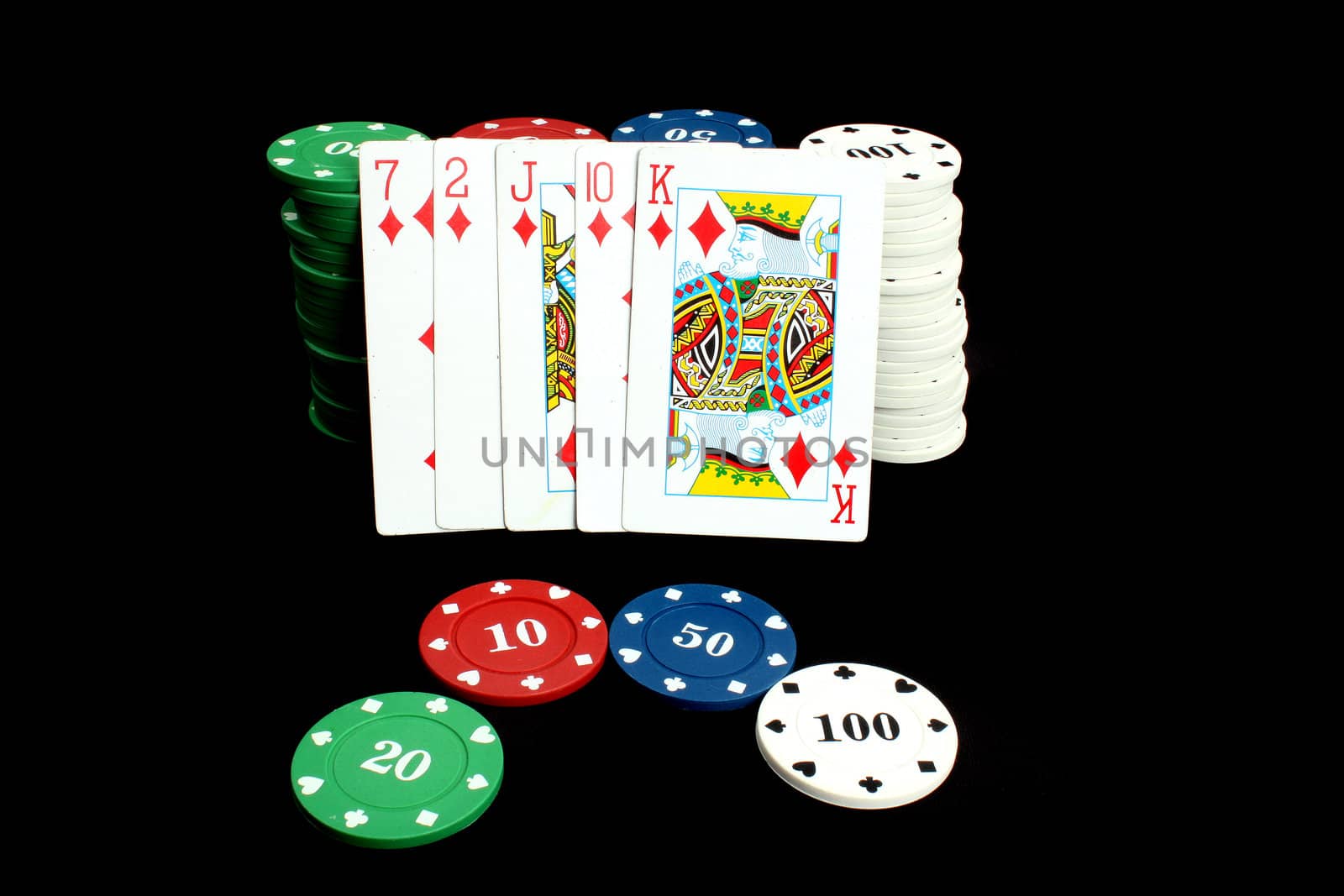 A Poker winning hand called 'Flush' consisting 5 cards of the same deck leaning on stacks of gambling chips, on black studio background.